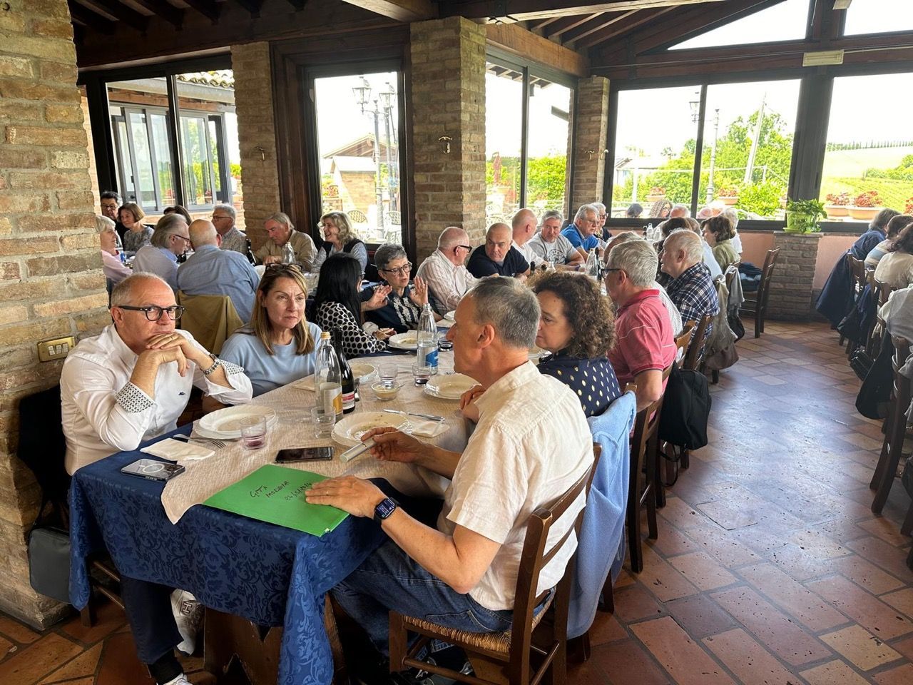 Un gruppo di persone è seduto ai tavoli di un ristorante.