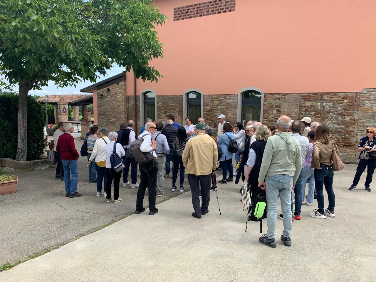Un gruppo di persone è in piedi davanti a un edificio.