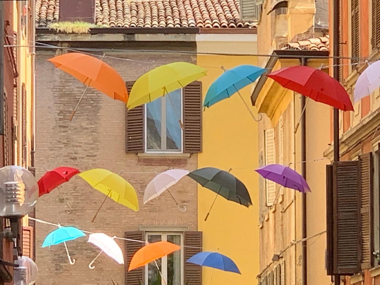 Un mazzo di ombrelli colorati sono appesi a una corda
