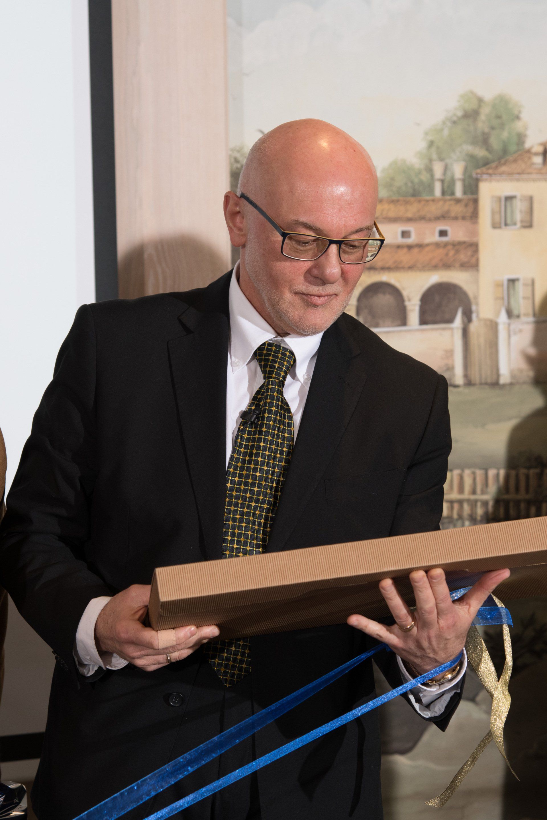 Un uomo in giacca e cravatta tiene in mano un pezzo di legno.