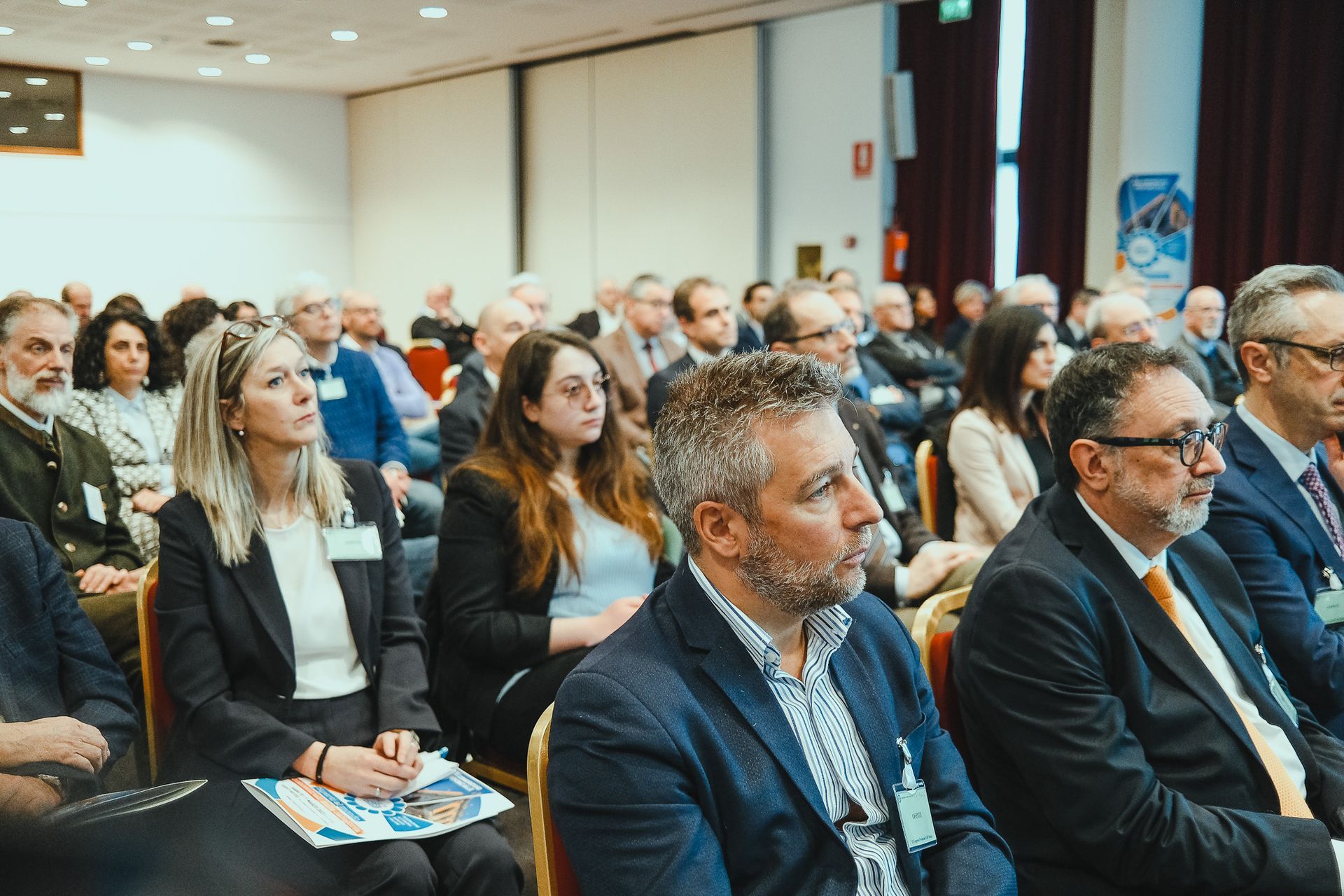 Un gruppo di persone è seduto in una stanza e guarda una presentazione.