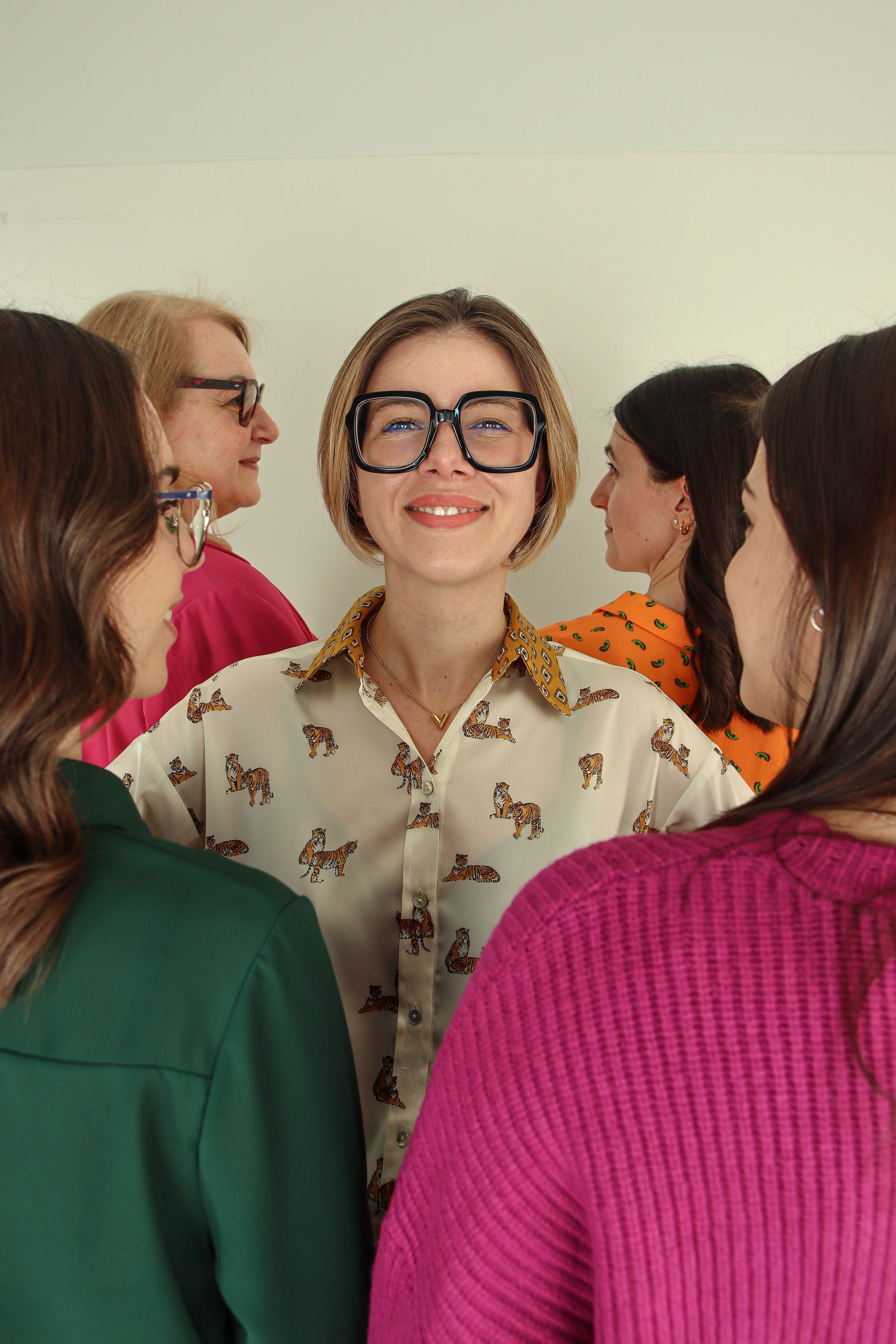 Un gruppo di donne è in piedi una accanto all'altra e una di loro indossa gli occhiali.