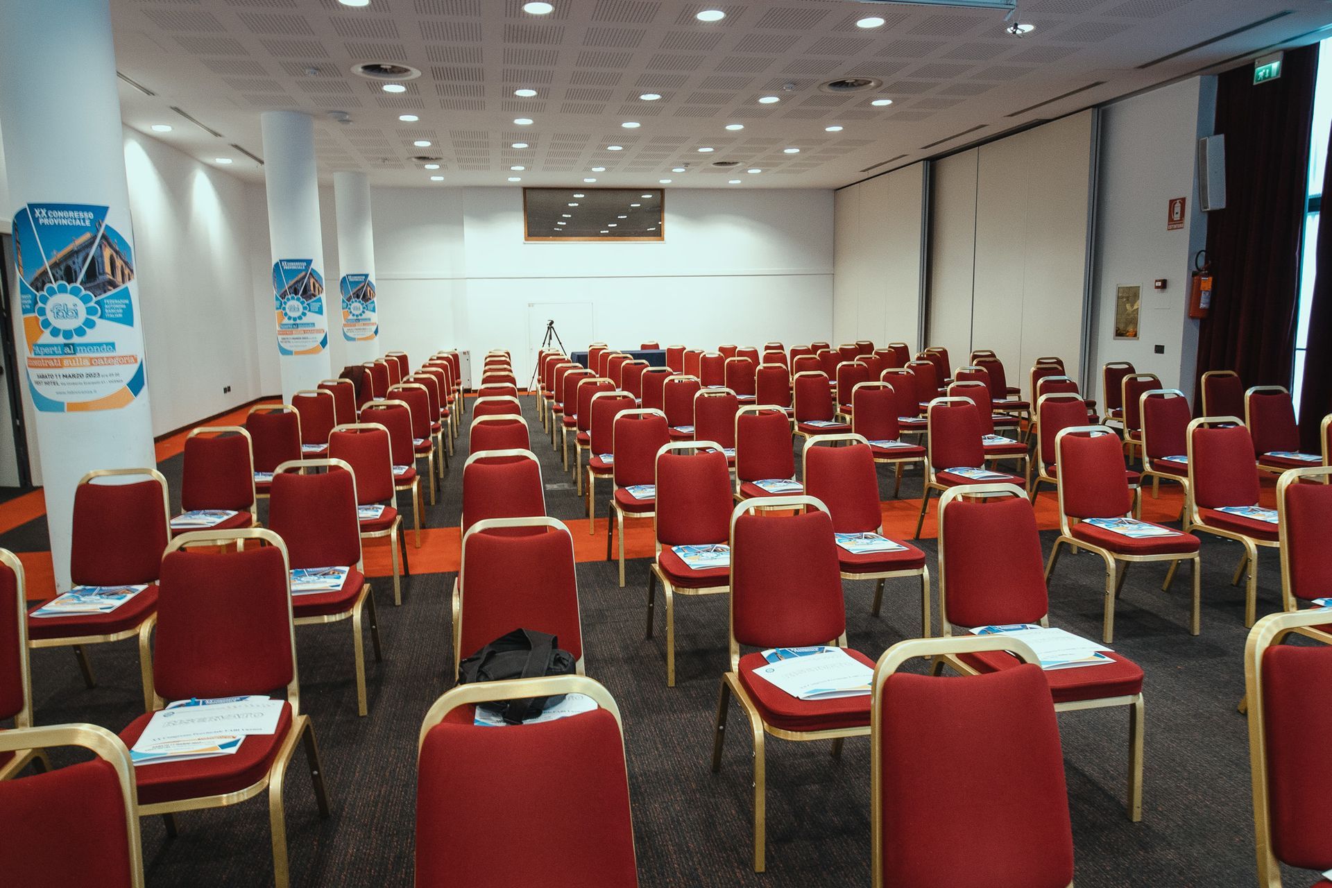 File di sedie rosse sono allineate in una grande stanza