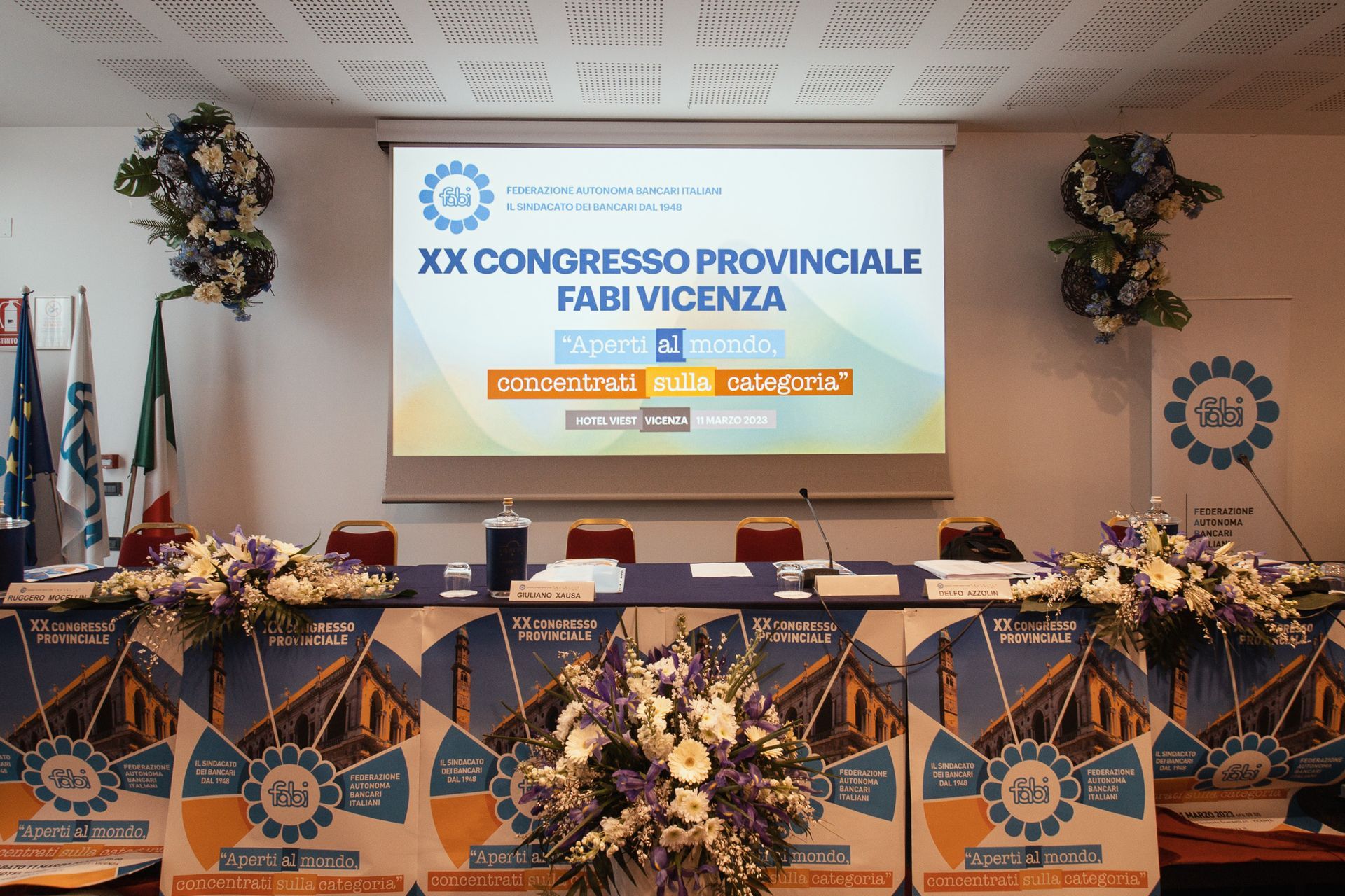 Una sala conferenze con uno schermo per proiettori che dice xx congreso provinciale fabi vicenza