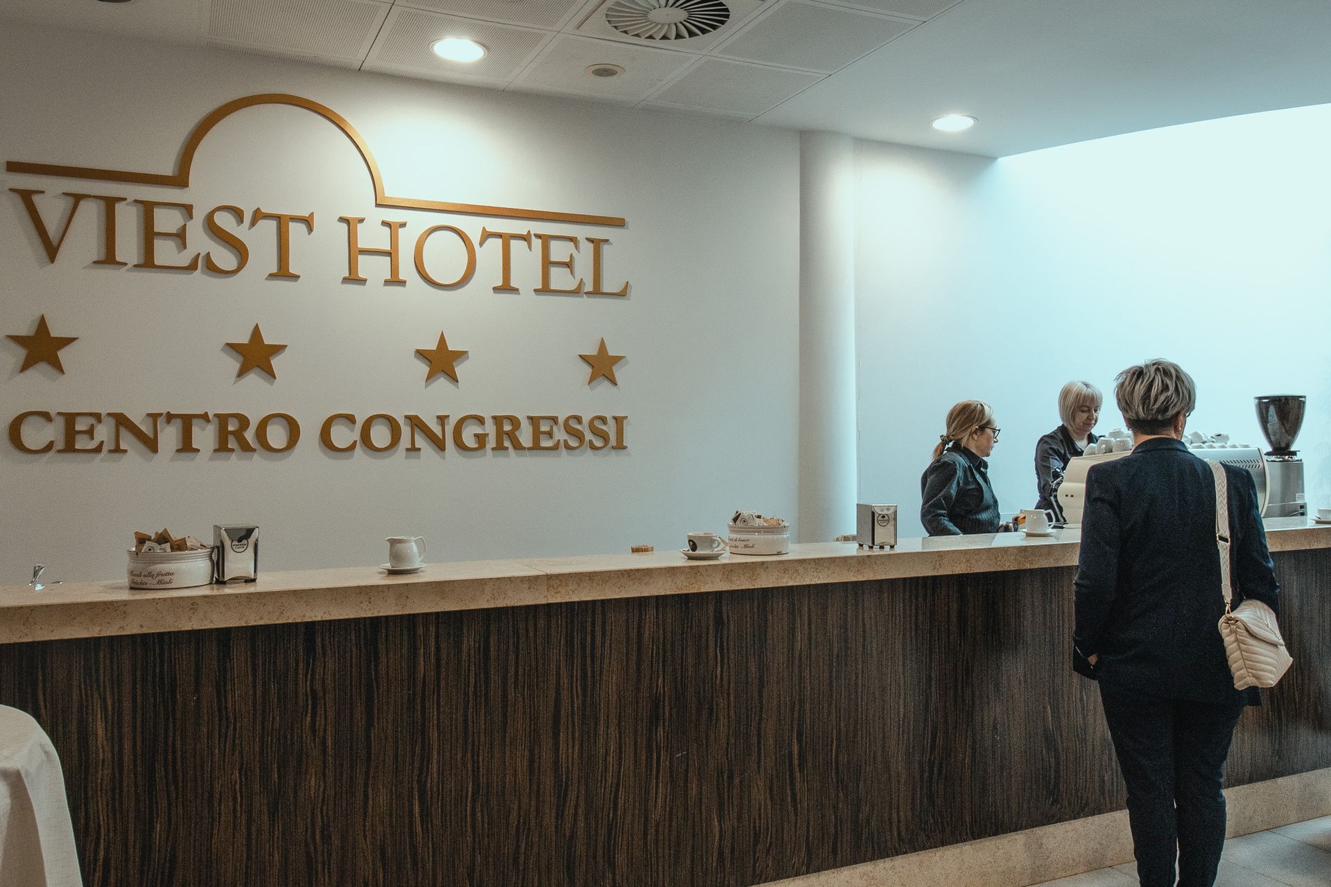 Una donna è in piedi davanti alla reception di un hotel.