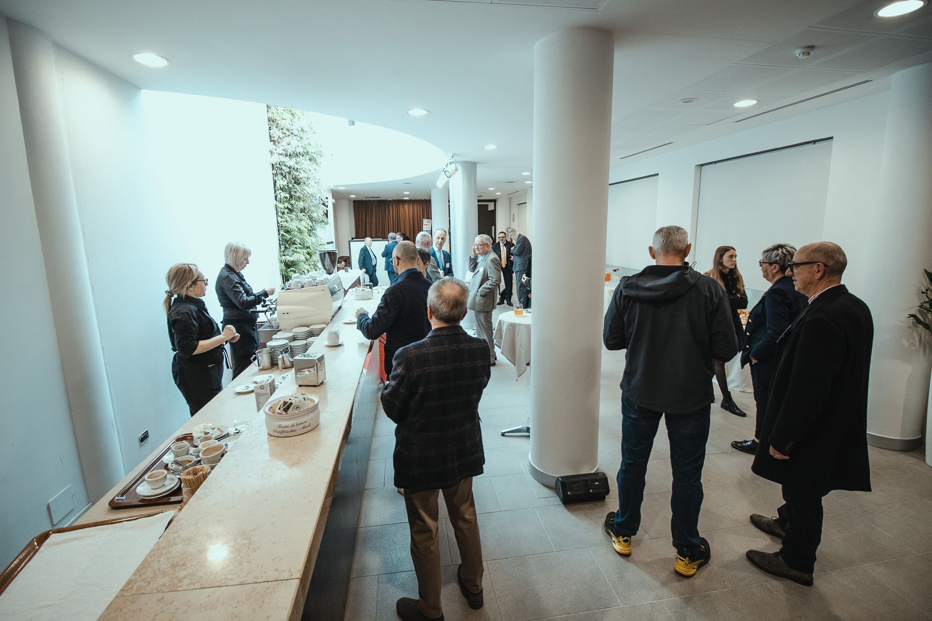 Un gruppo di persone è in piedi attorno al bancone di una stanza.