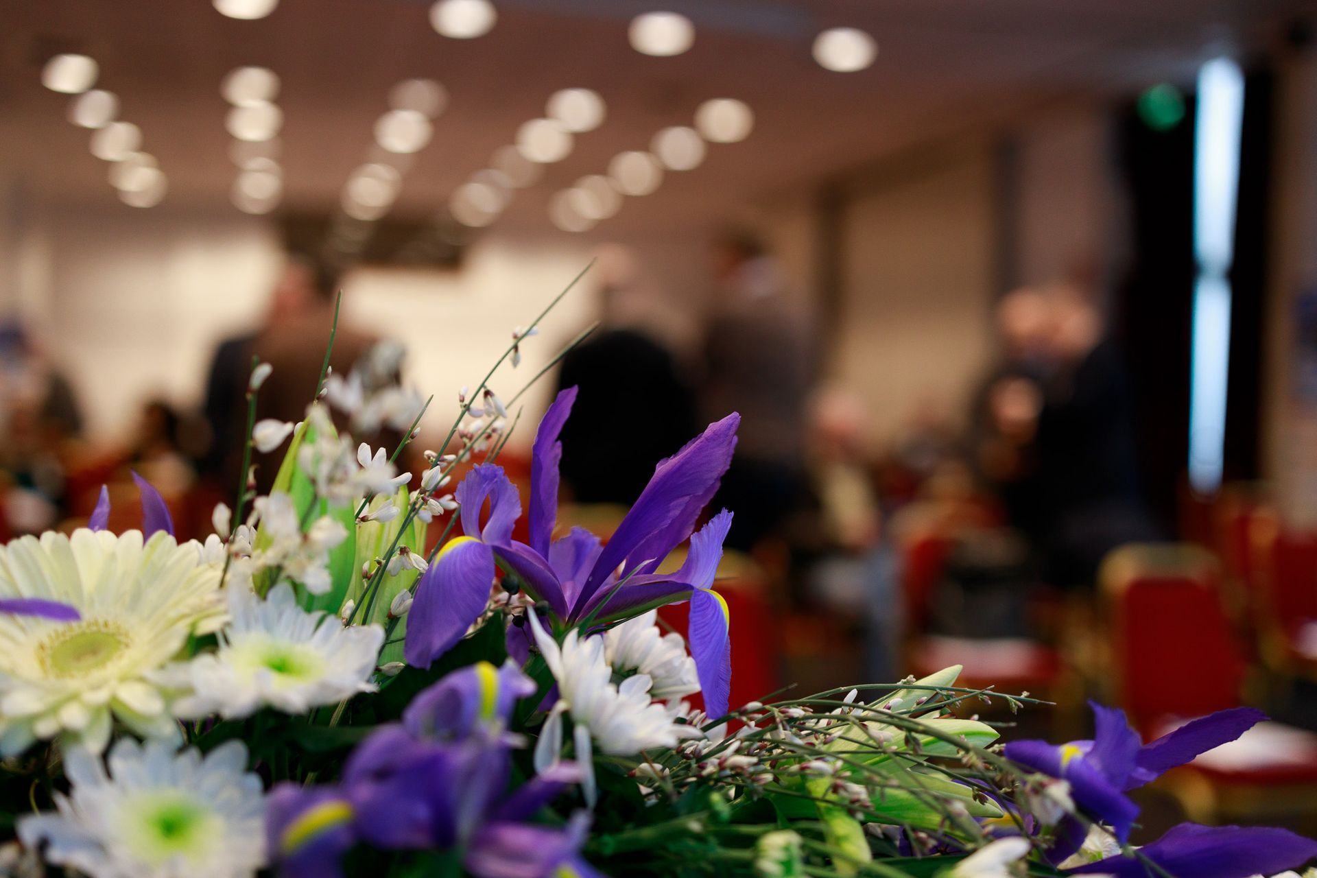 Un mazzo di fiori è seduto su un tavolo in una stanza.
