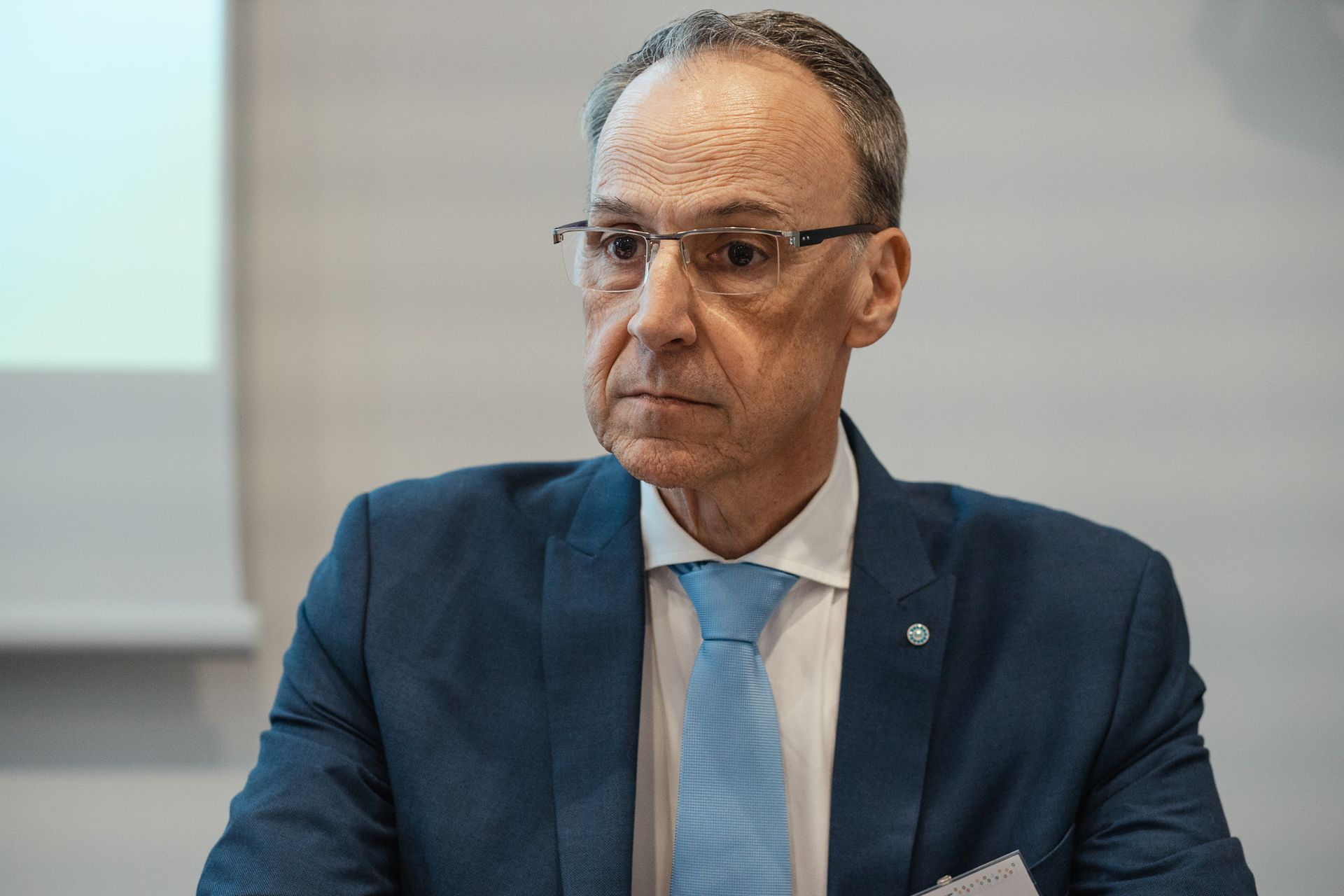 Un uomo in giacca e cravatta è seduto a un tavolo.