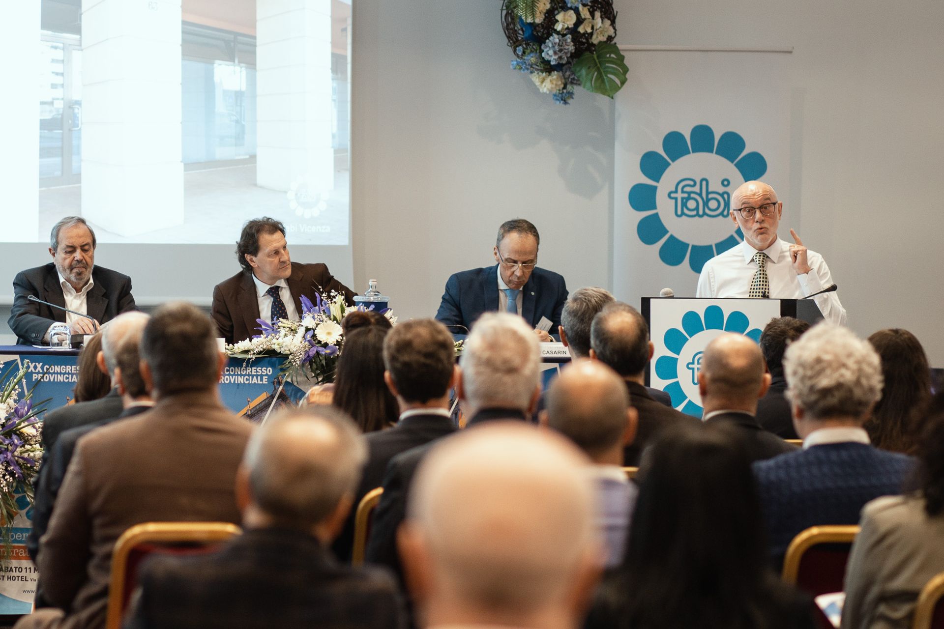 Un gruppo di persone è seduto in una stanza e guarda una presentazione.
