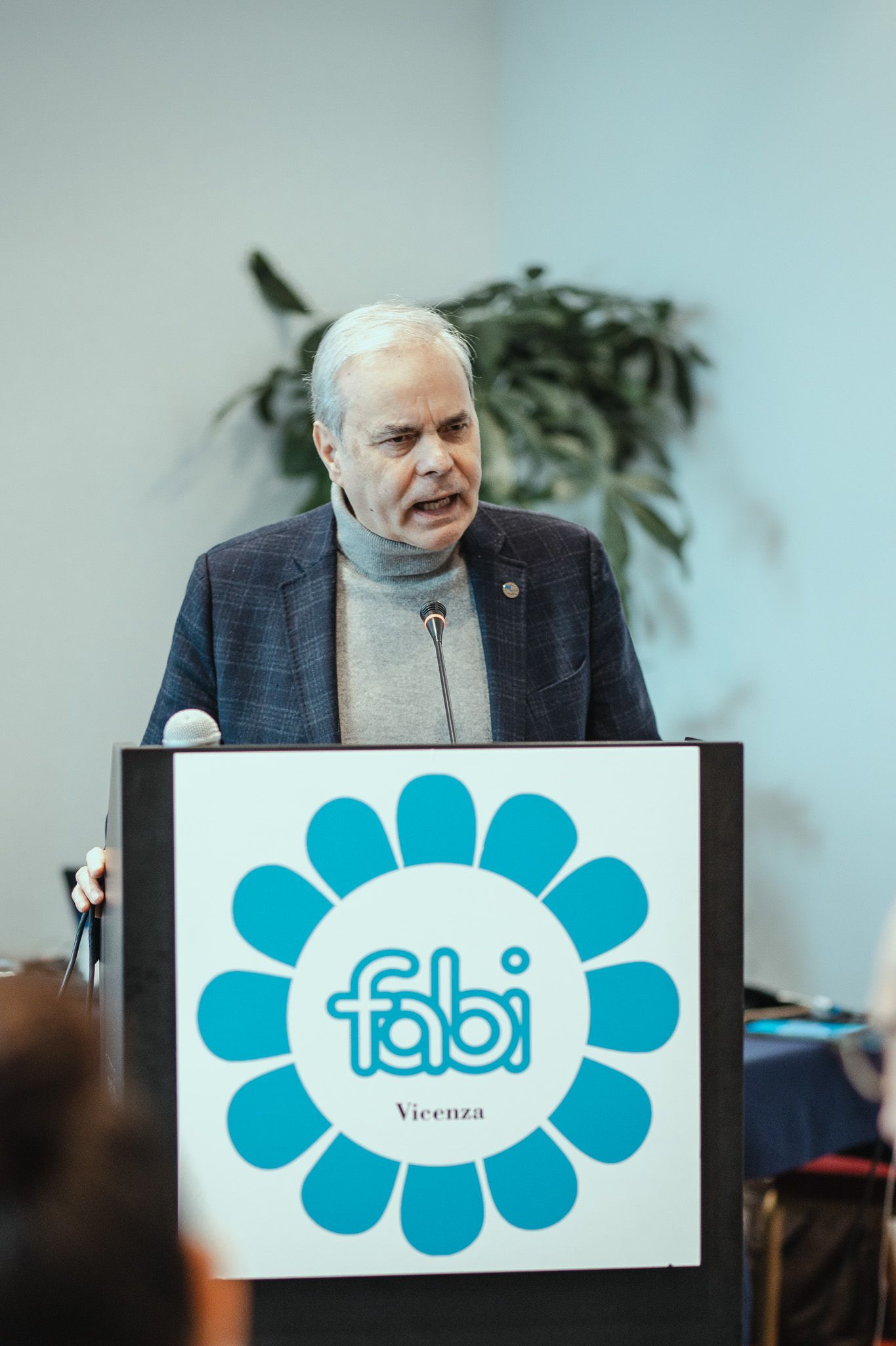Un uomo è in piedi su un podio con sopra il logo Fabi