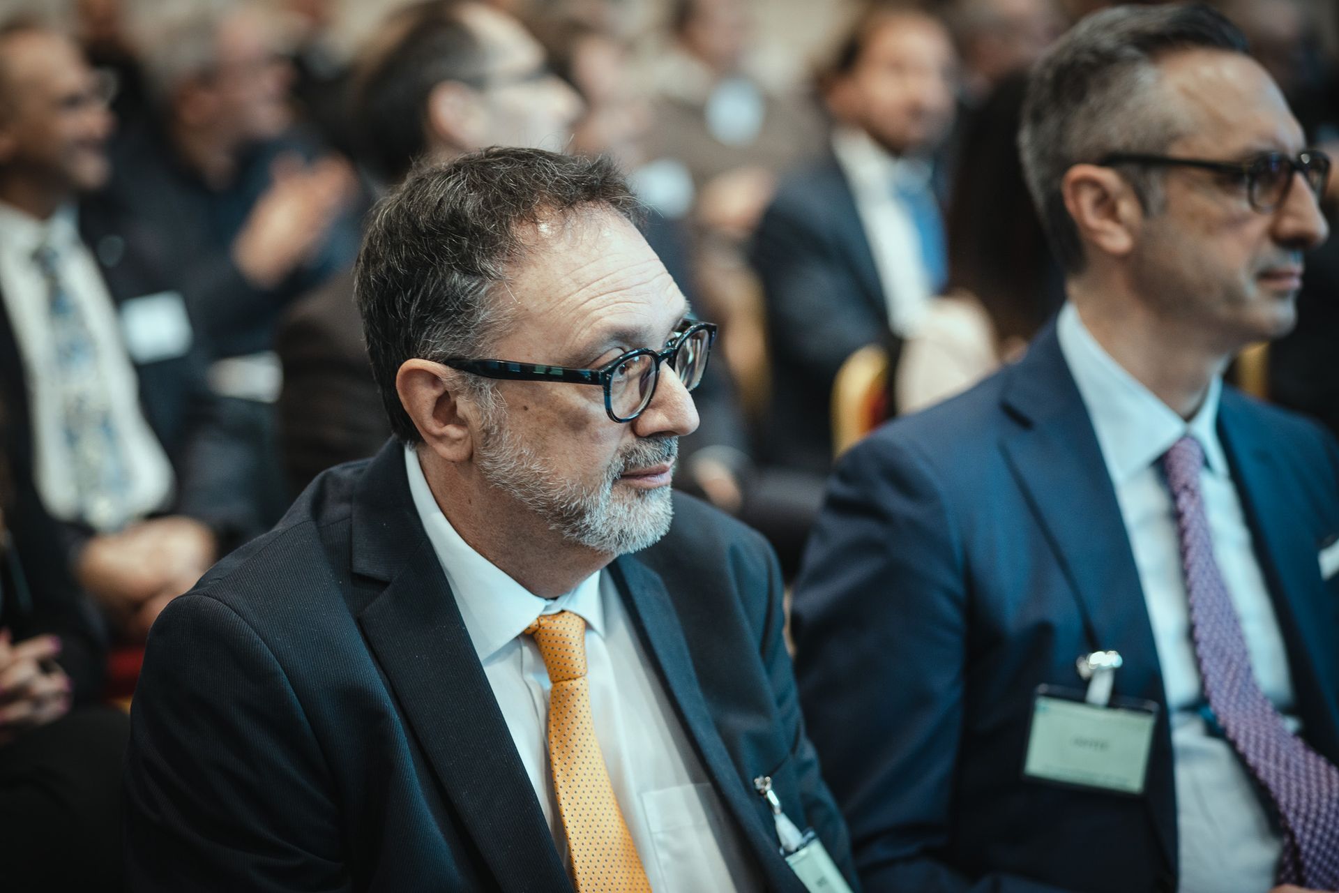 Due uomini in giacca e cravatta sono seduti in una stanza.