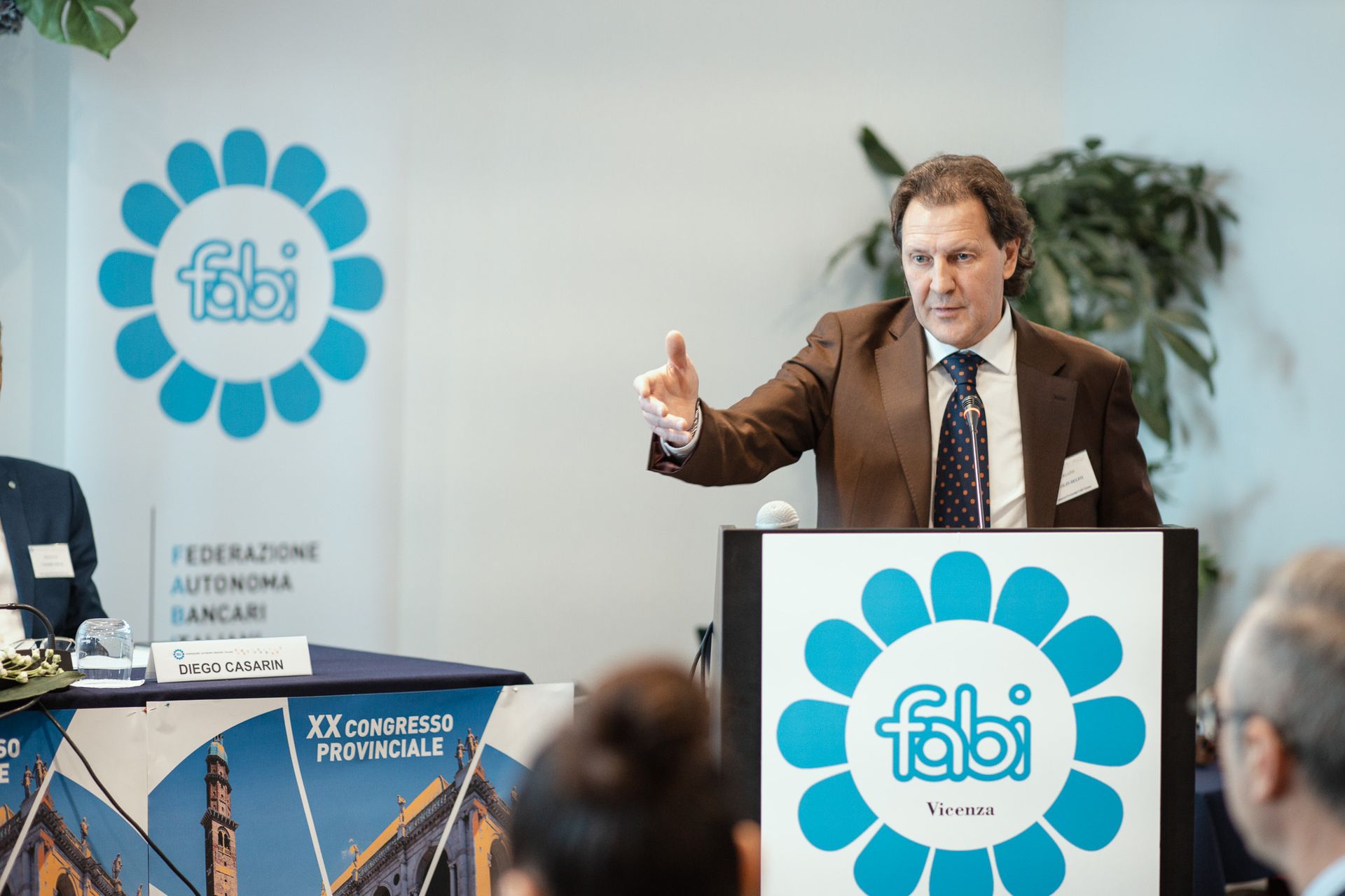 Un uomo in giacca e cravatta è in piedi su un podio e tiene un discorso.