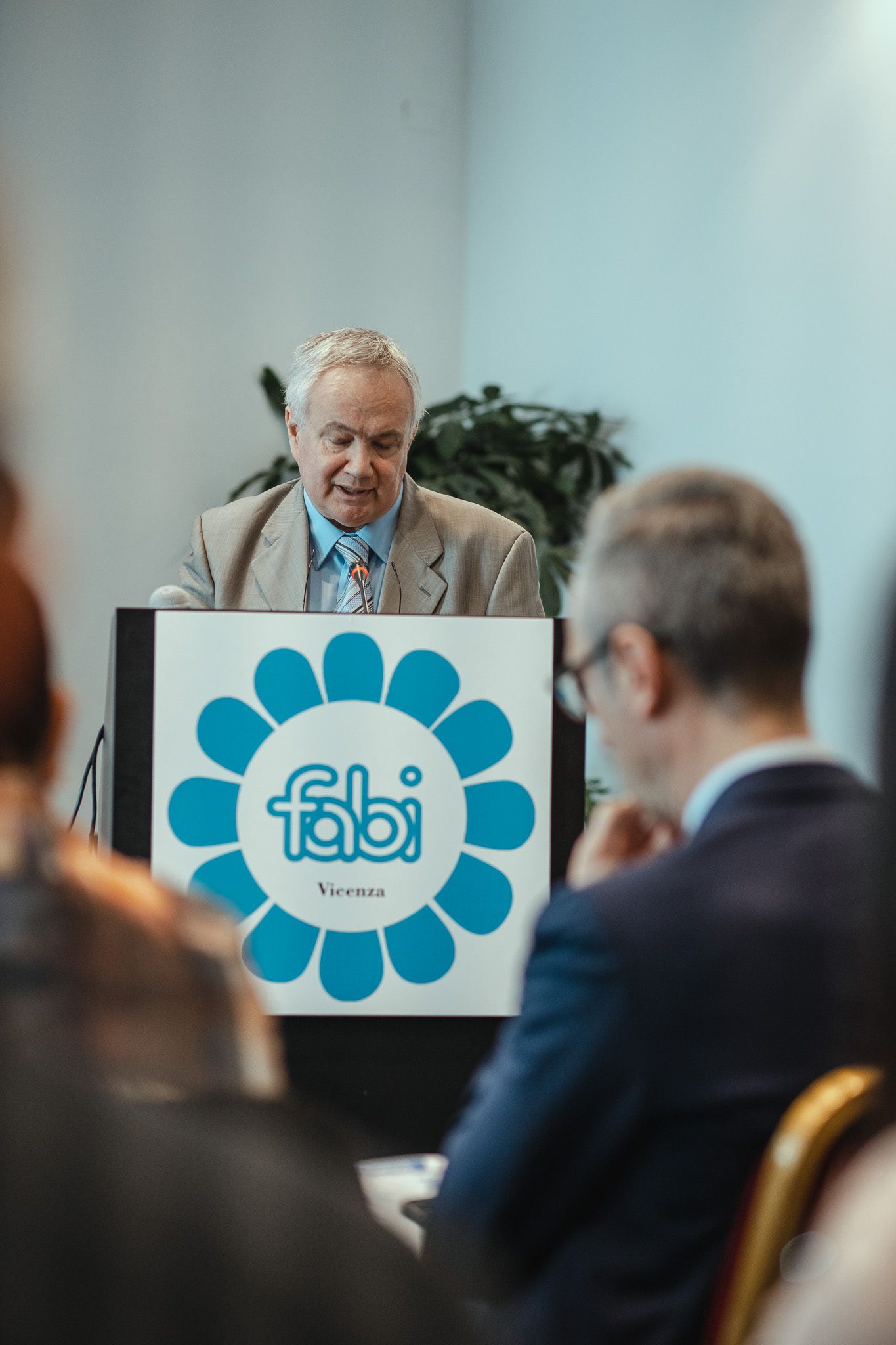Un uomo tiene un discorso su un podio con sopra il logo Fabi.