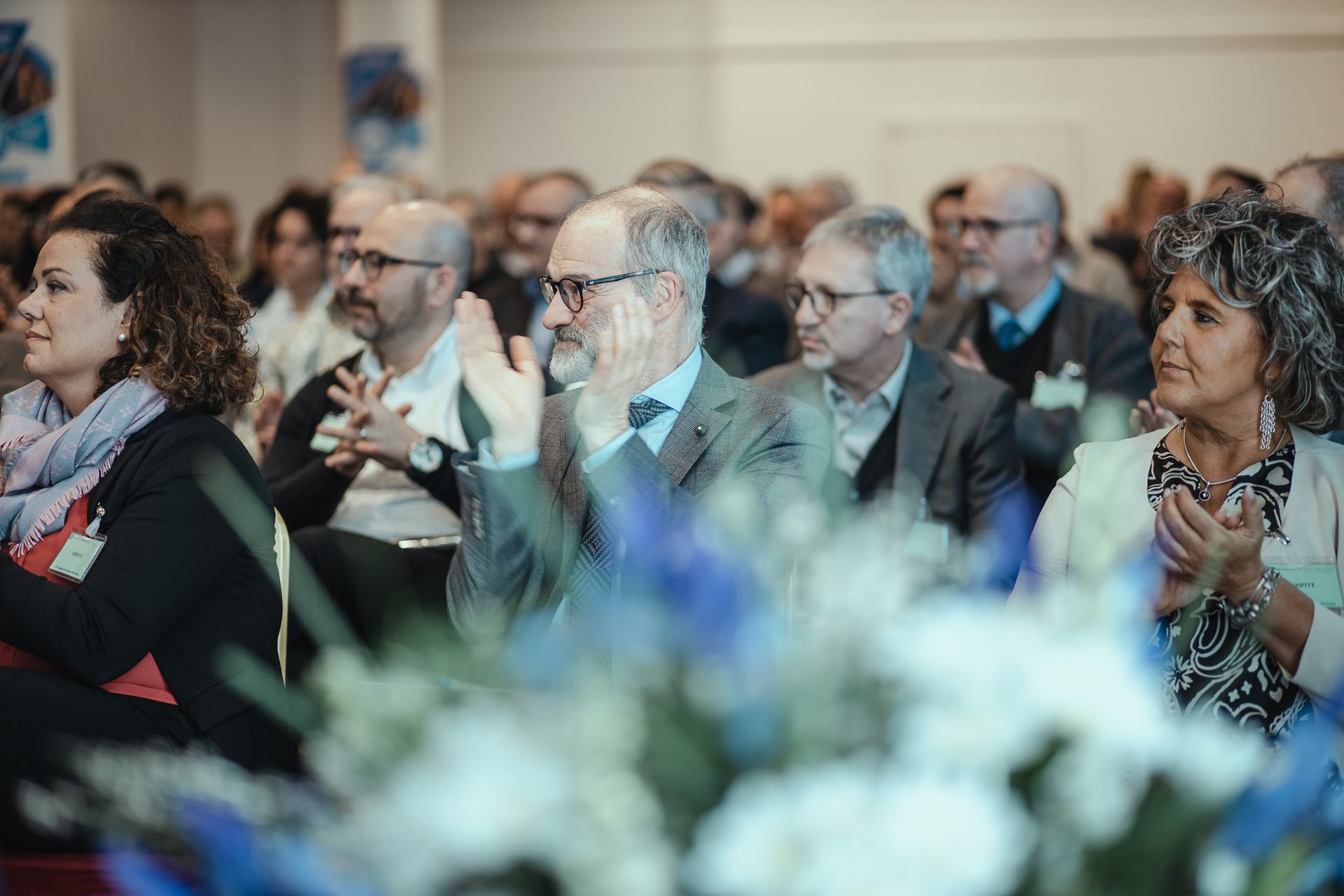 Un gruppo di persone è seduto in una stanza e applaude.