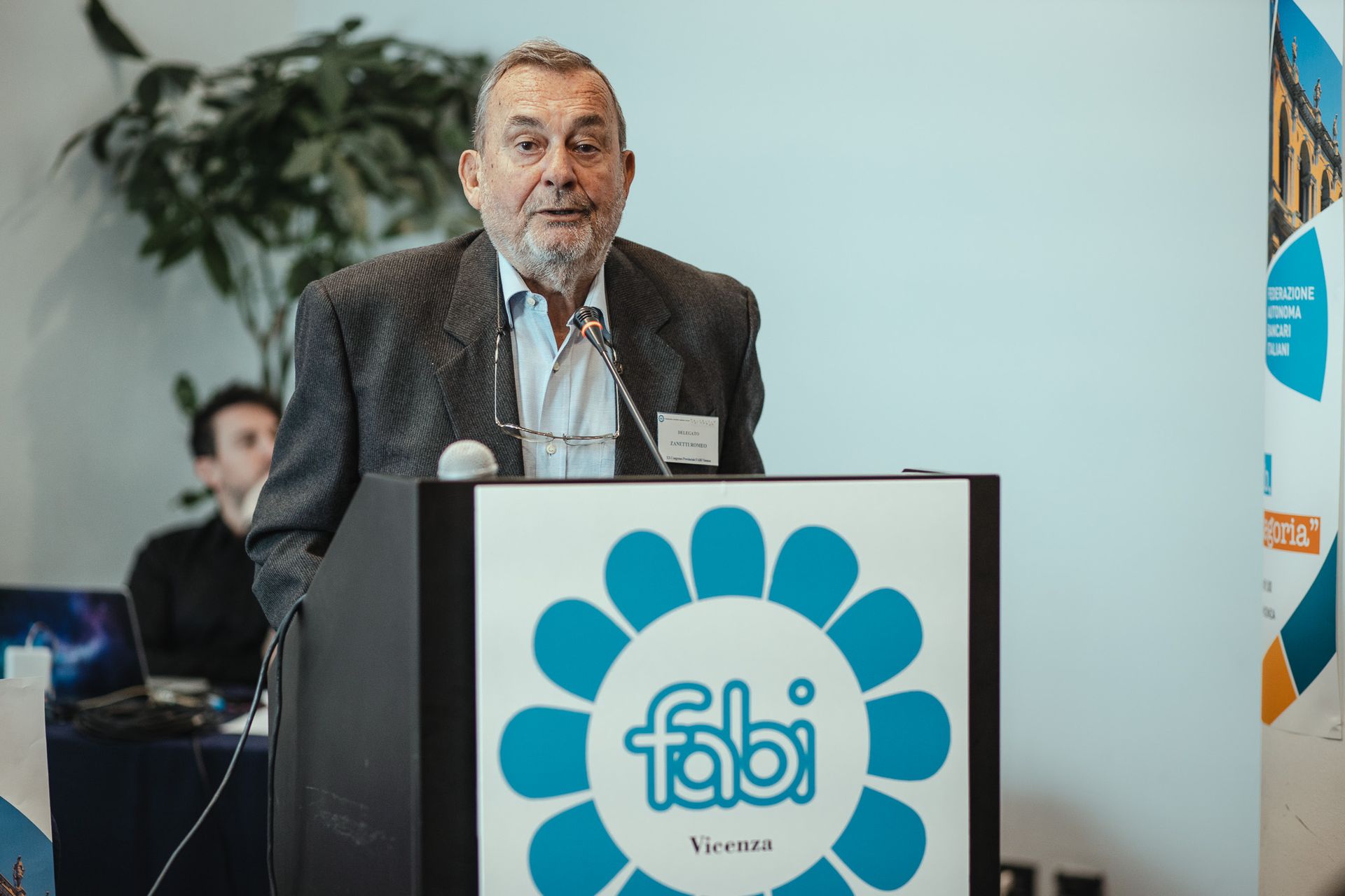 Un uomo è in piedi su un podio con sopra il logo Fabi.