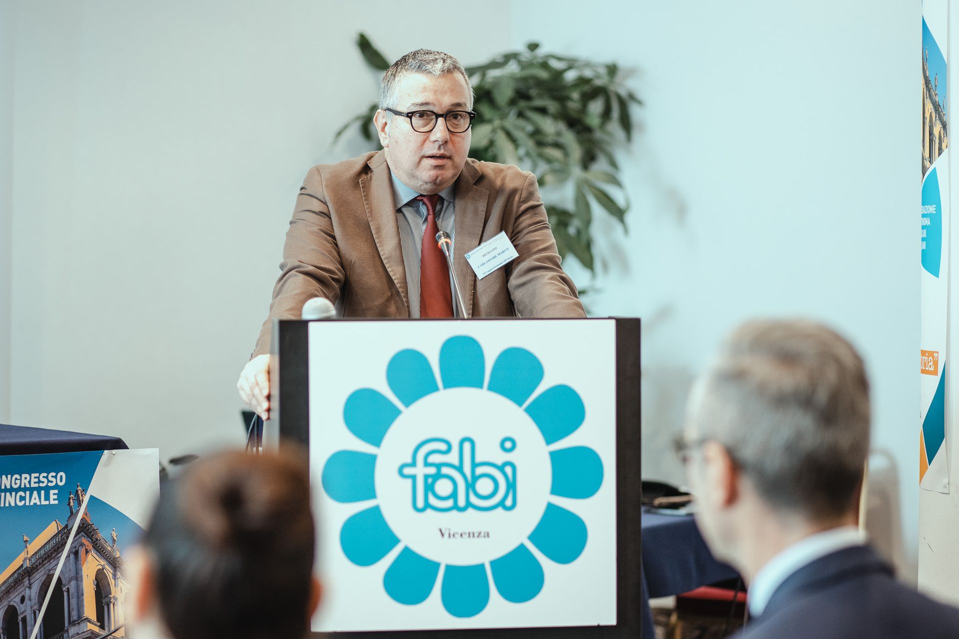 Un uomo è in piedi su un podio con sopra il logo Fabi.