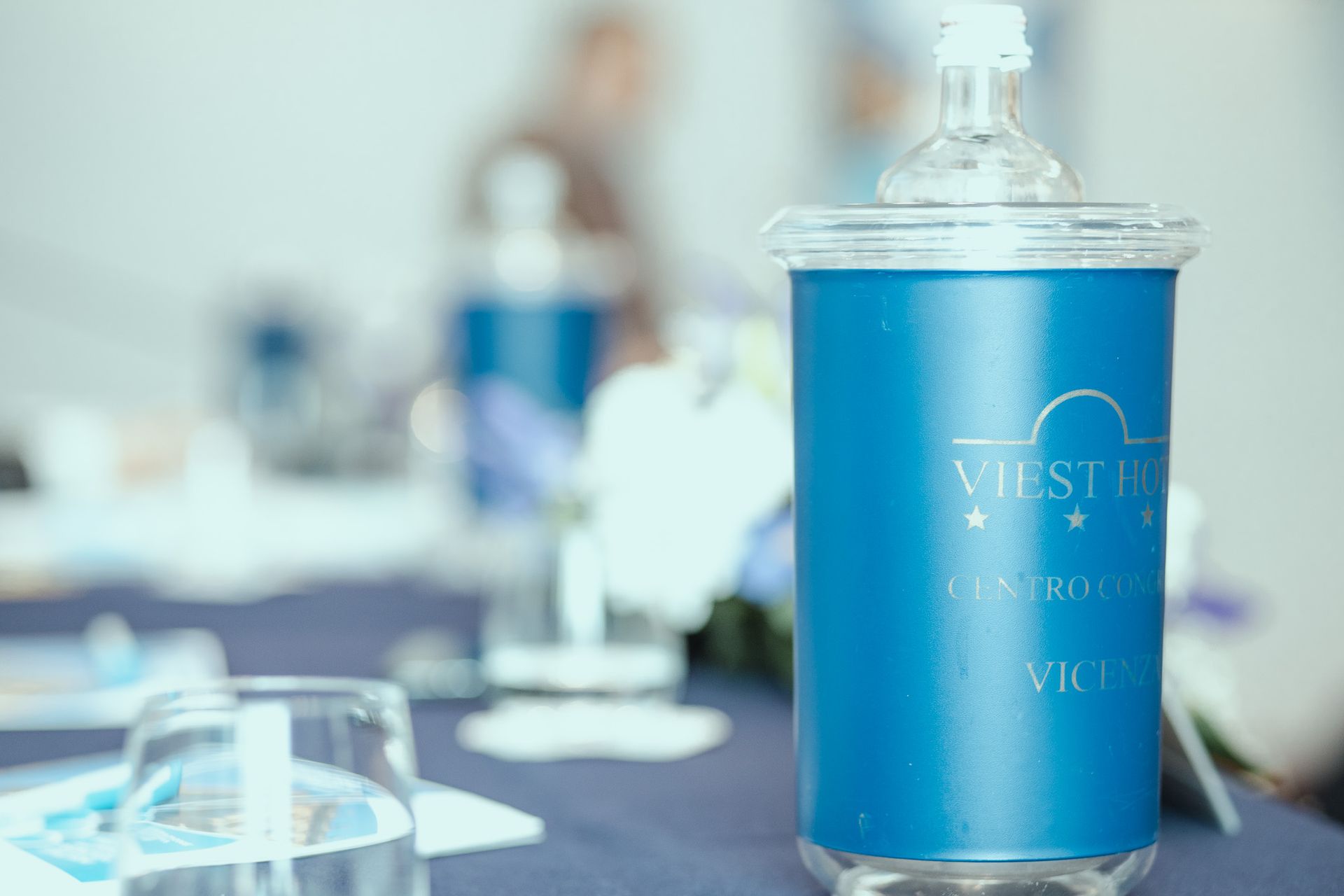 Una bottiglia d'acqua blu è seduta su un tavolo.