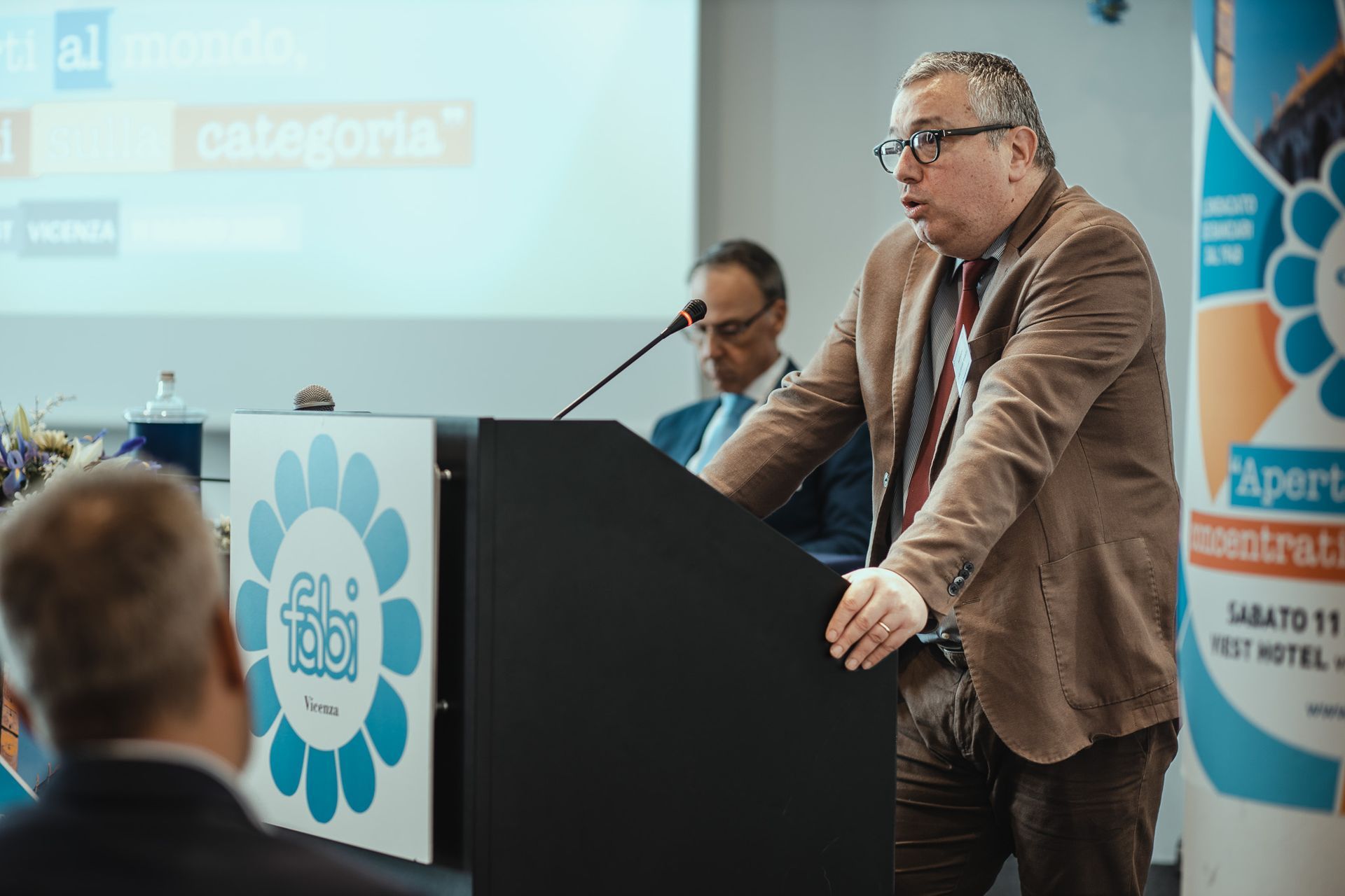 Un uomo è in piedi su un podio e tiene un discorso.