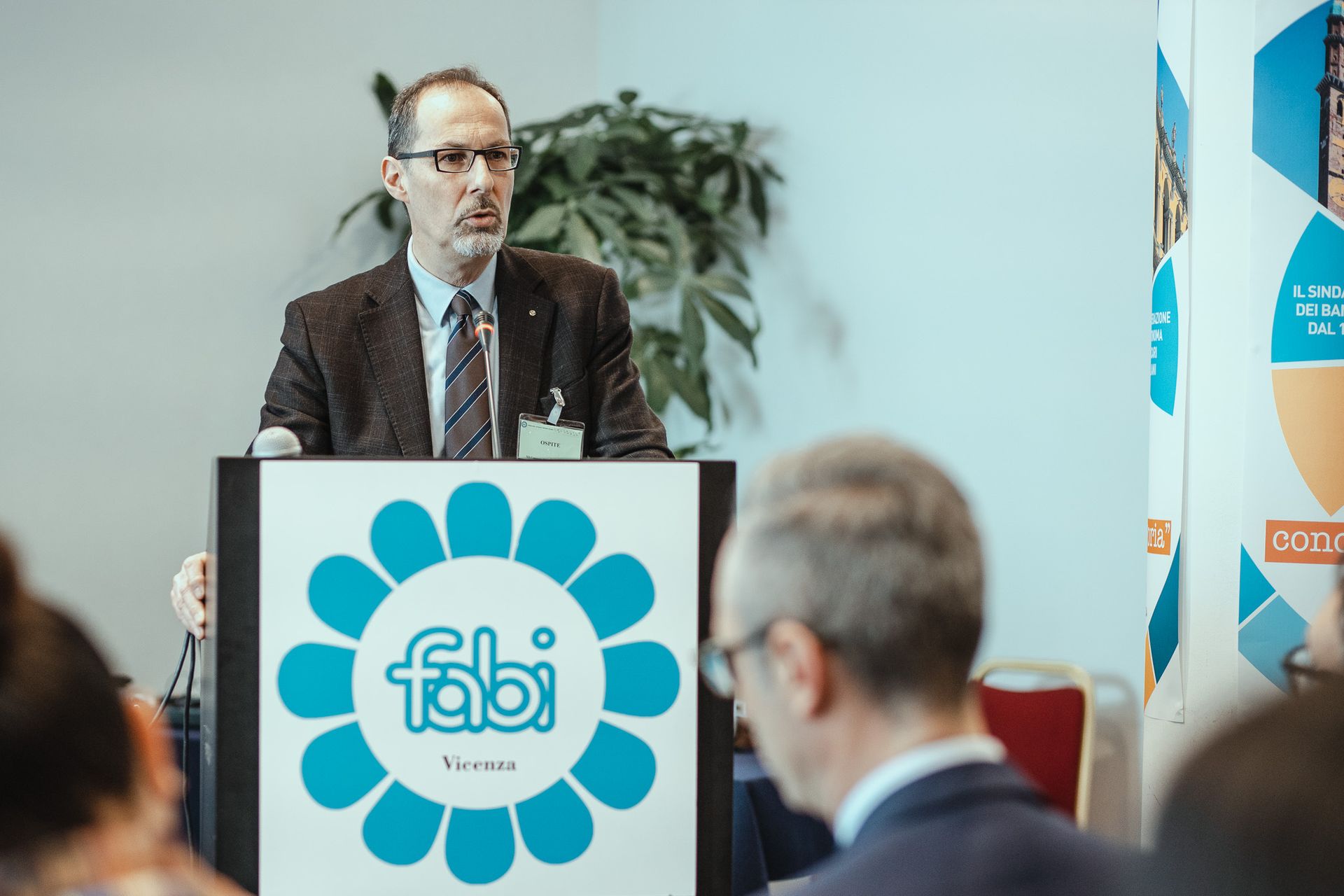 Un uomo è in piedi su un podio con sopra il logo Fabi.
