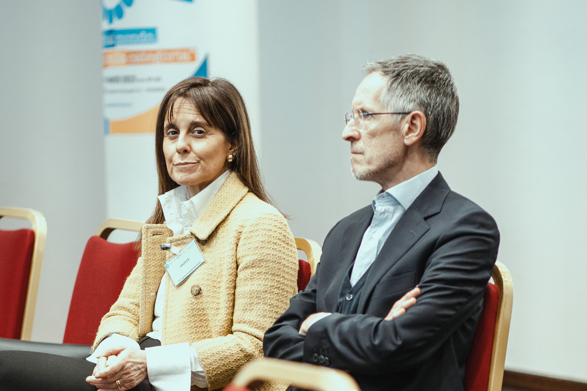 Un uomo e una donna sono seduti sulle sedie in una stanza.