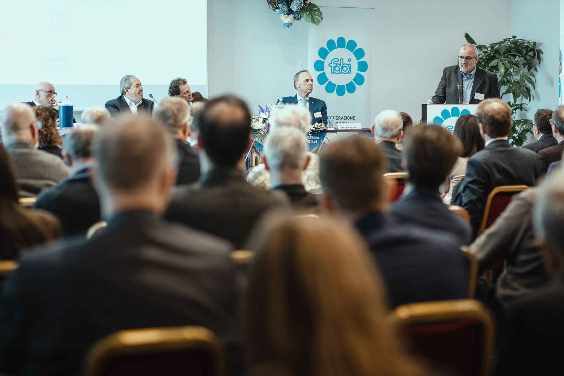 Un uomo sta facendo una presentazione a un gruppo di persone in una sala conferenze.
