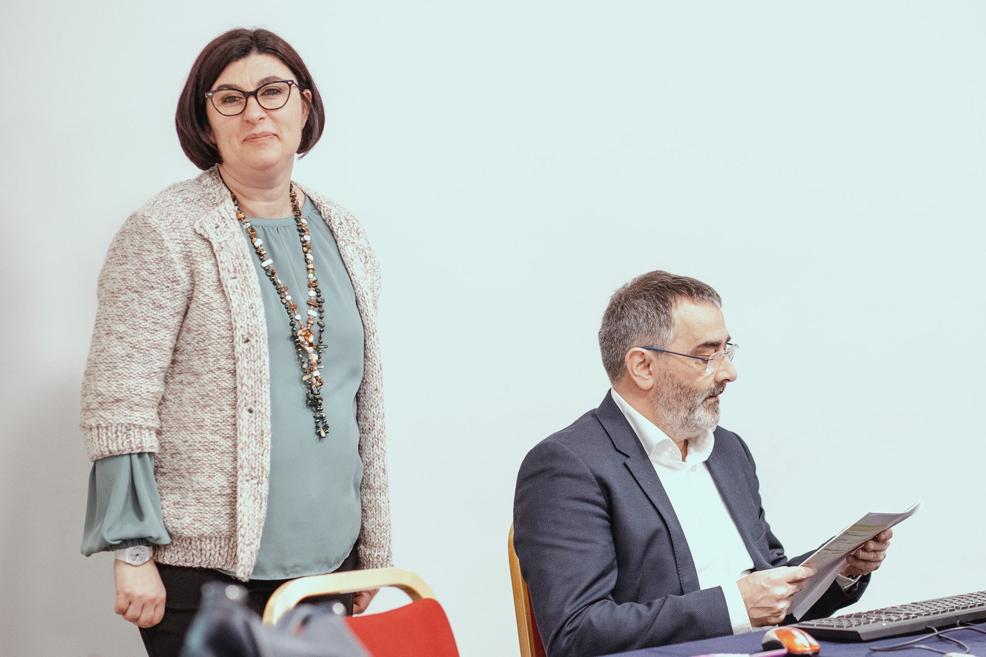 Una donna è in piedi accanto a un uomo in giacca e cravatta.