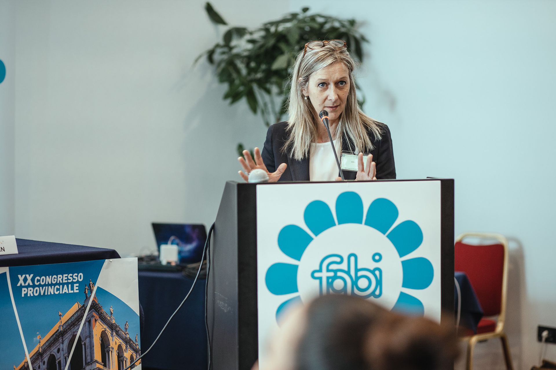 Una donna tiene un discorso su un podio con sopra il logo Fabi.