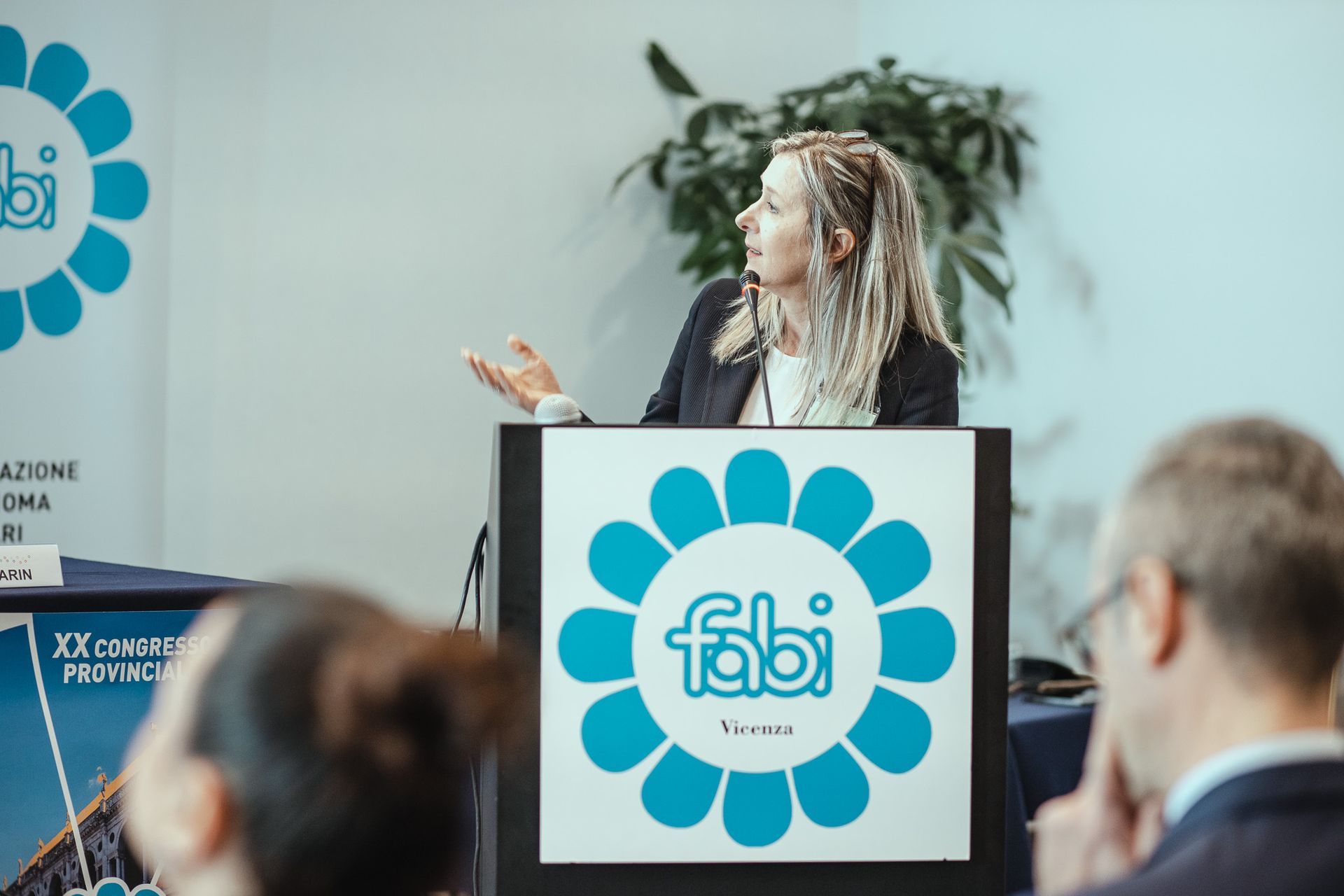 Una donna è in piedi su un podio con sopra il logo Fabi