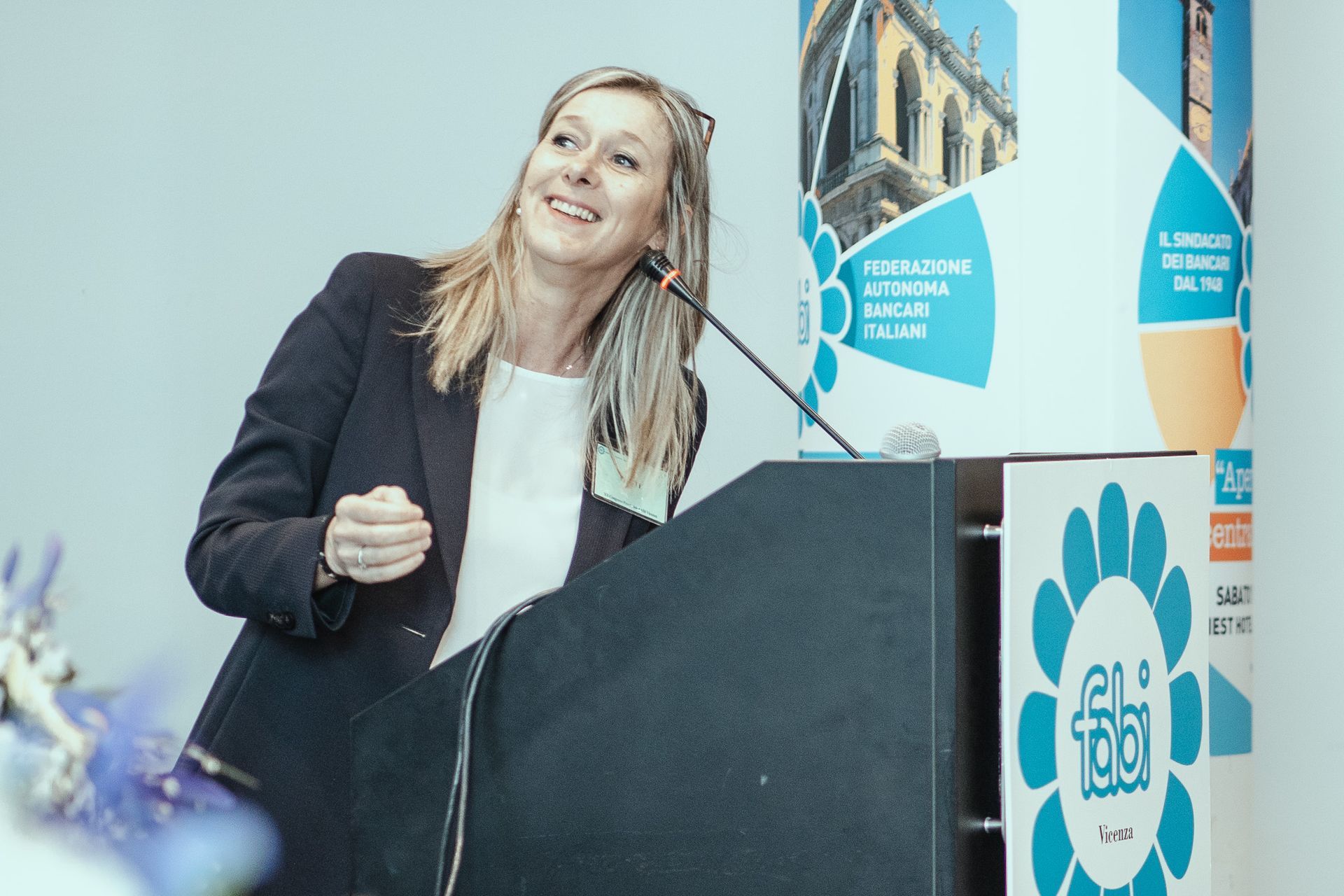 Una donna è in piedi su un podio e tiene un discorso.