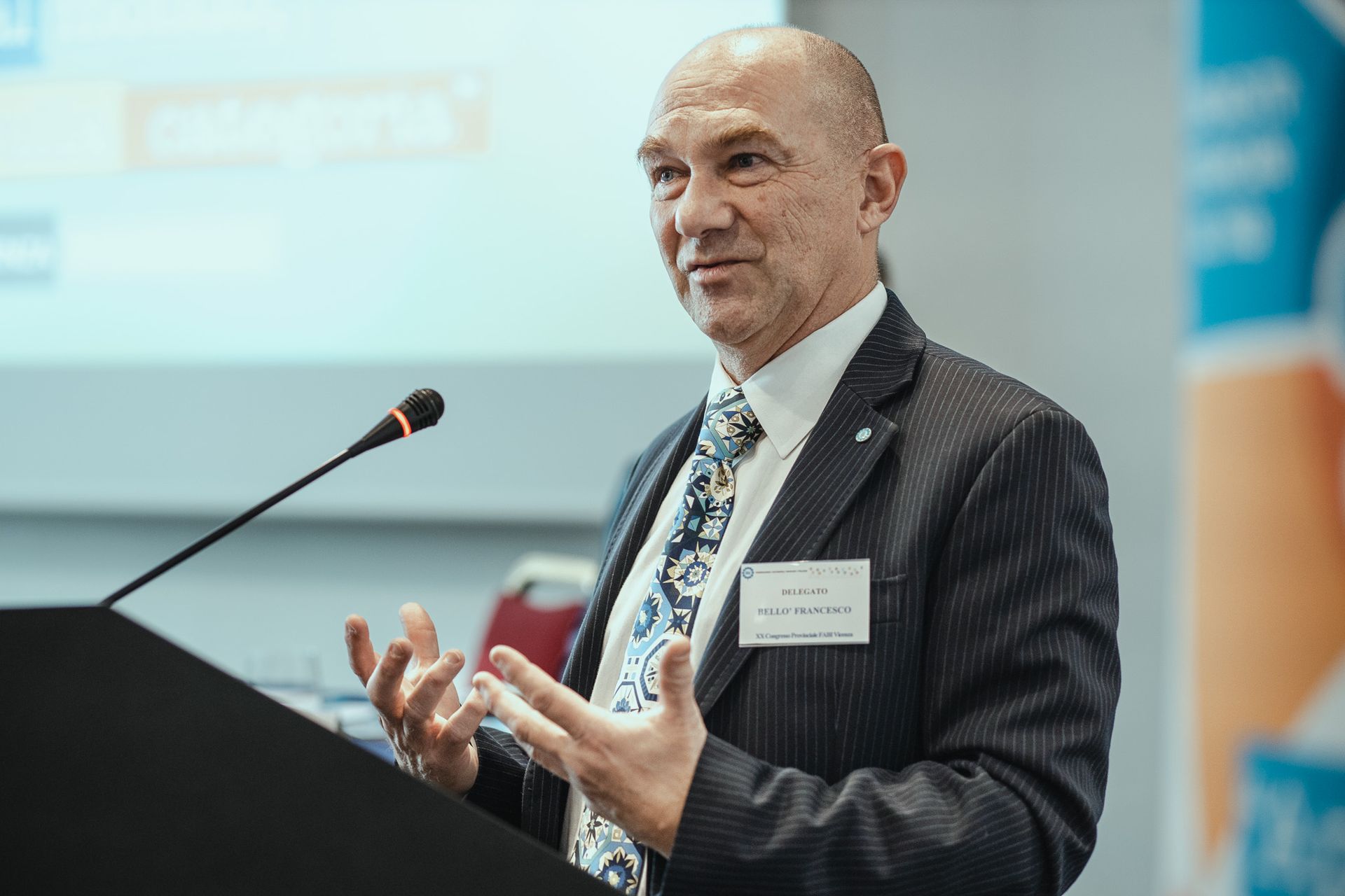 Un uomo in giacca e cravatta è in piedi su un podio e tiene un discorso.