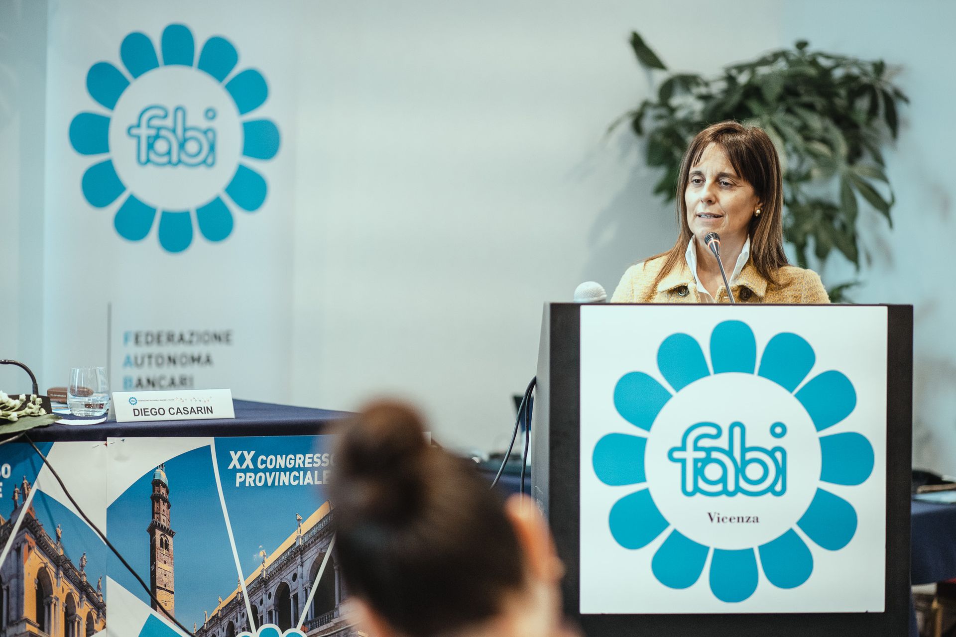 Una donna è in piedi su un podio con sopra il logo Fabi