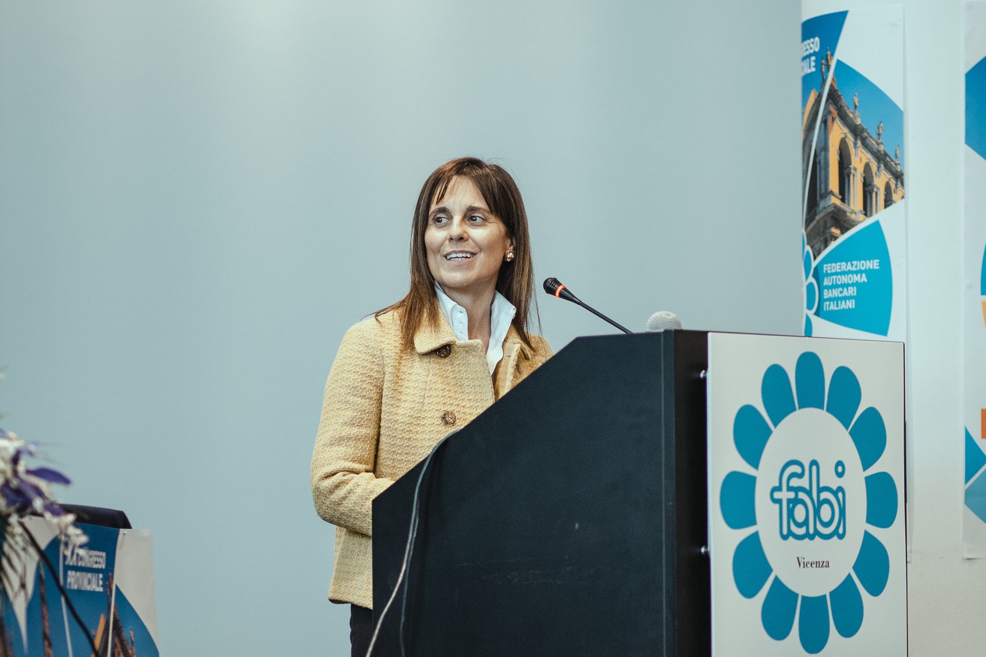 Una donna è in piedi su un podio e tiene un discorso.