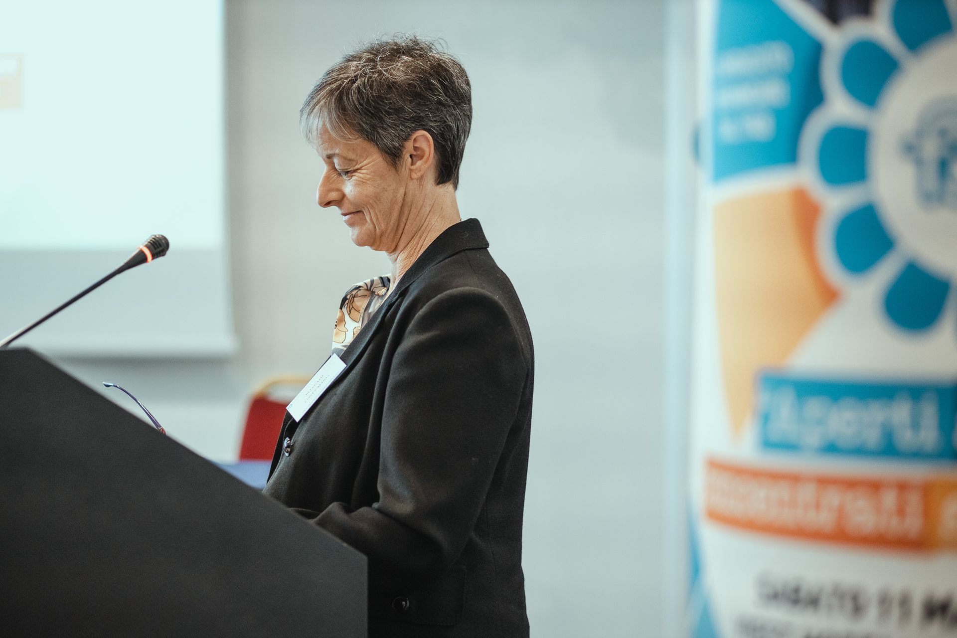 Una donna è in piedi su un podio con un microfono.