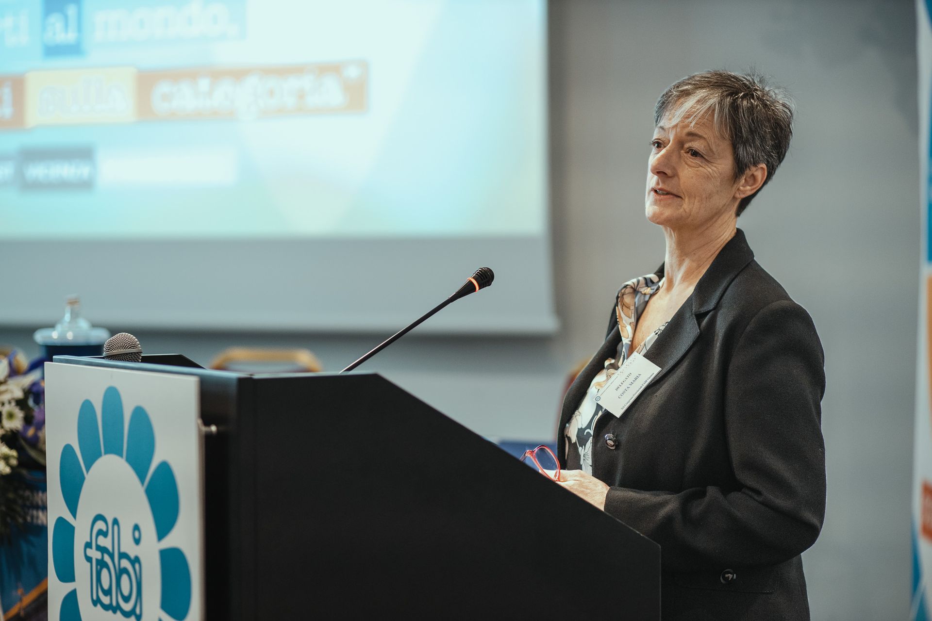 Una donna è in piedi su un podio e tiene un discorso.