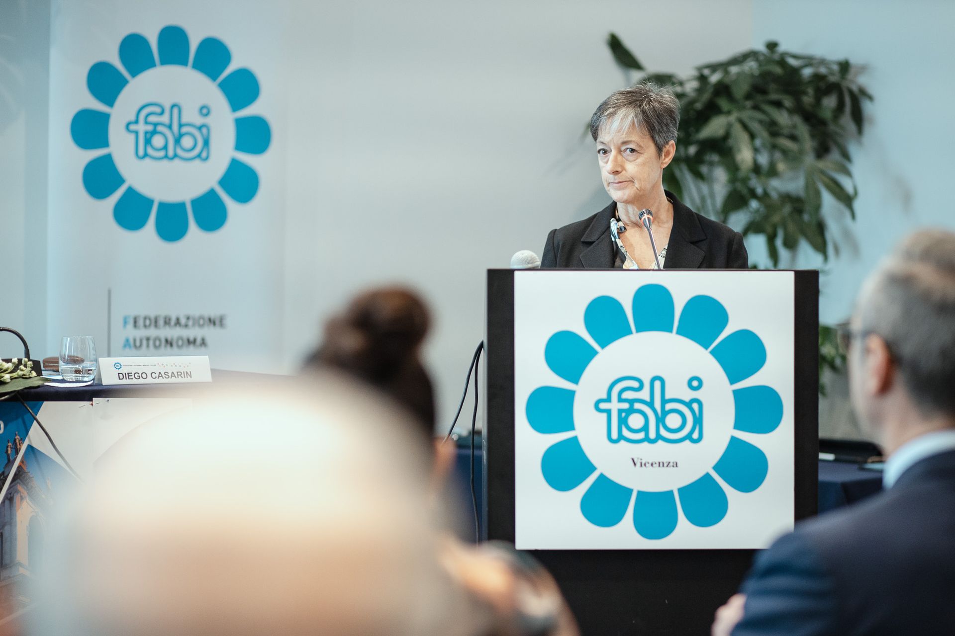 Una donna tiene un discorso su un podio con sopra il logo Fabi.