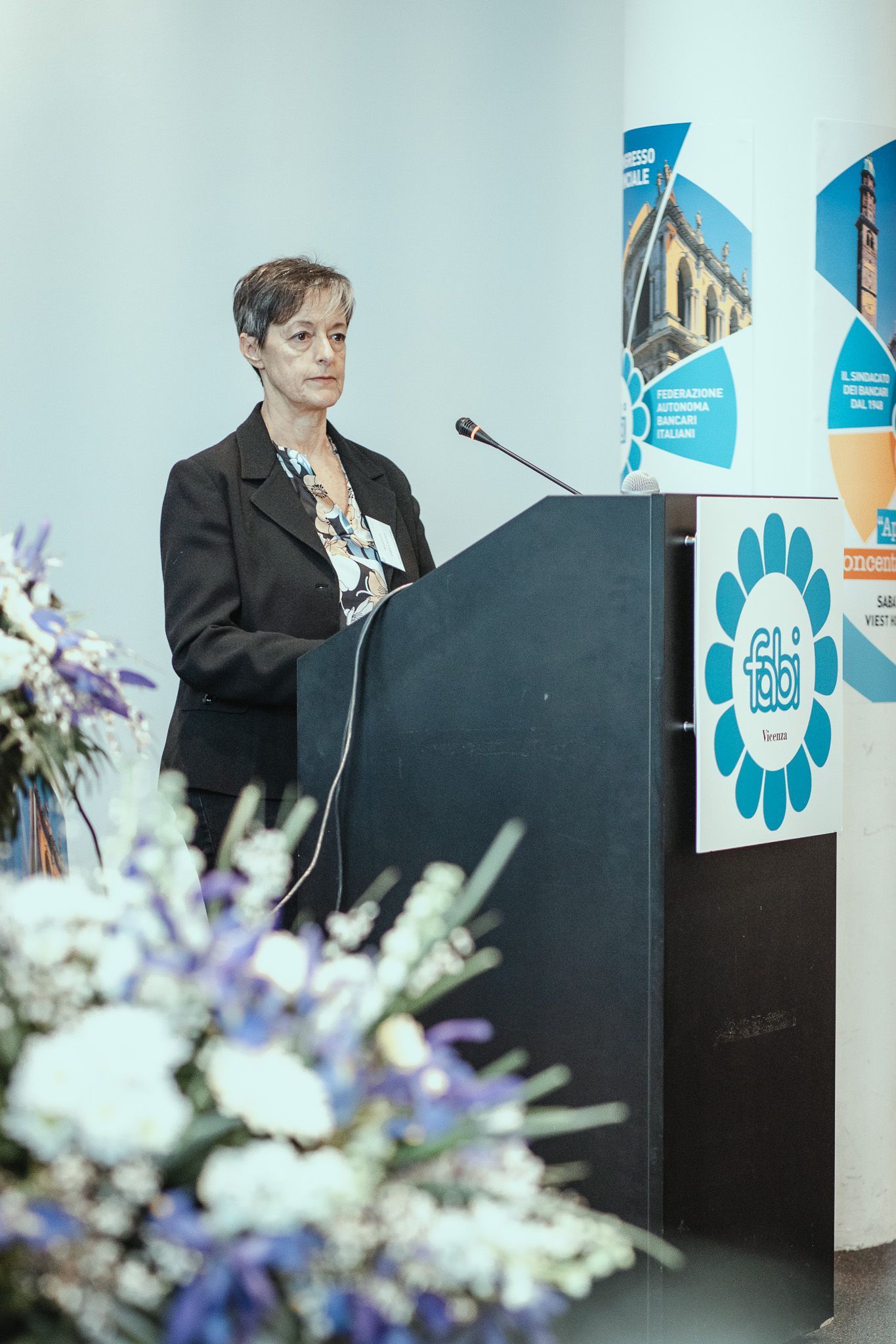 Una donna è in piedi su un podio e tiene un discorso.