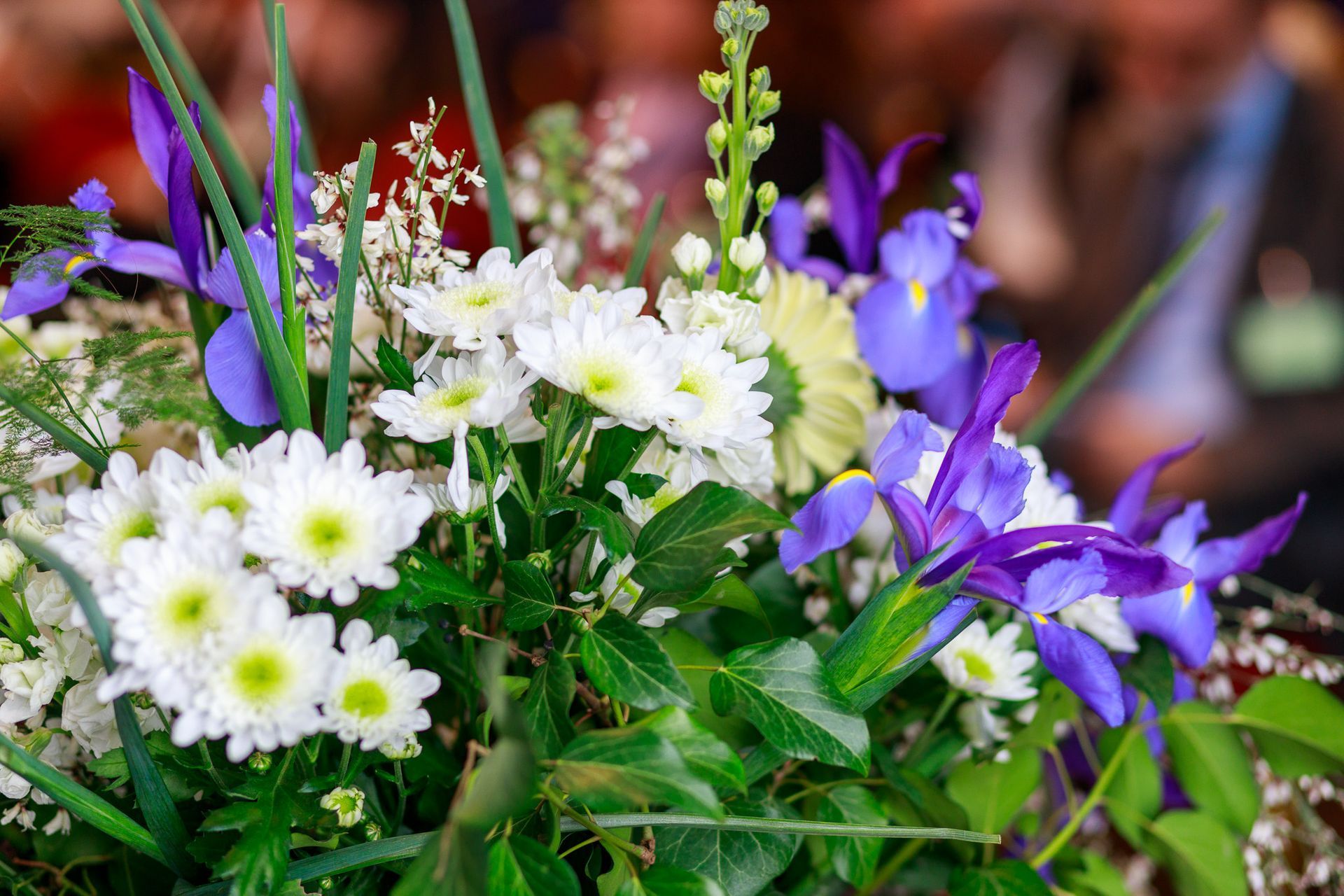Un primo piano di un mazzo di fiori bianchi e viola su un tavolo.