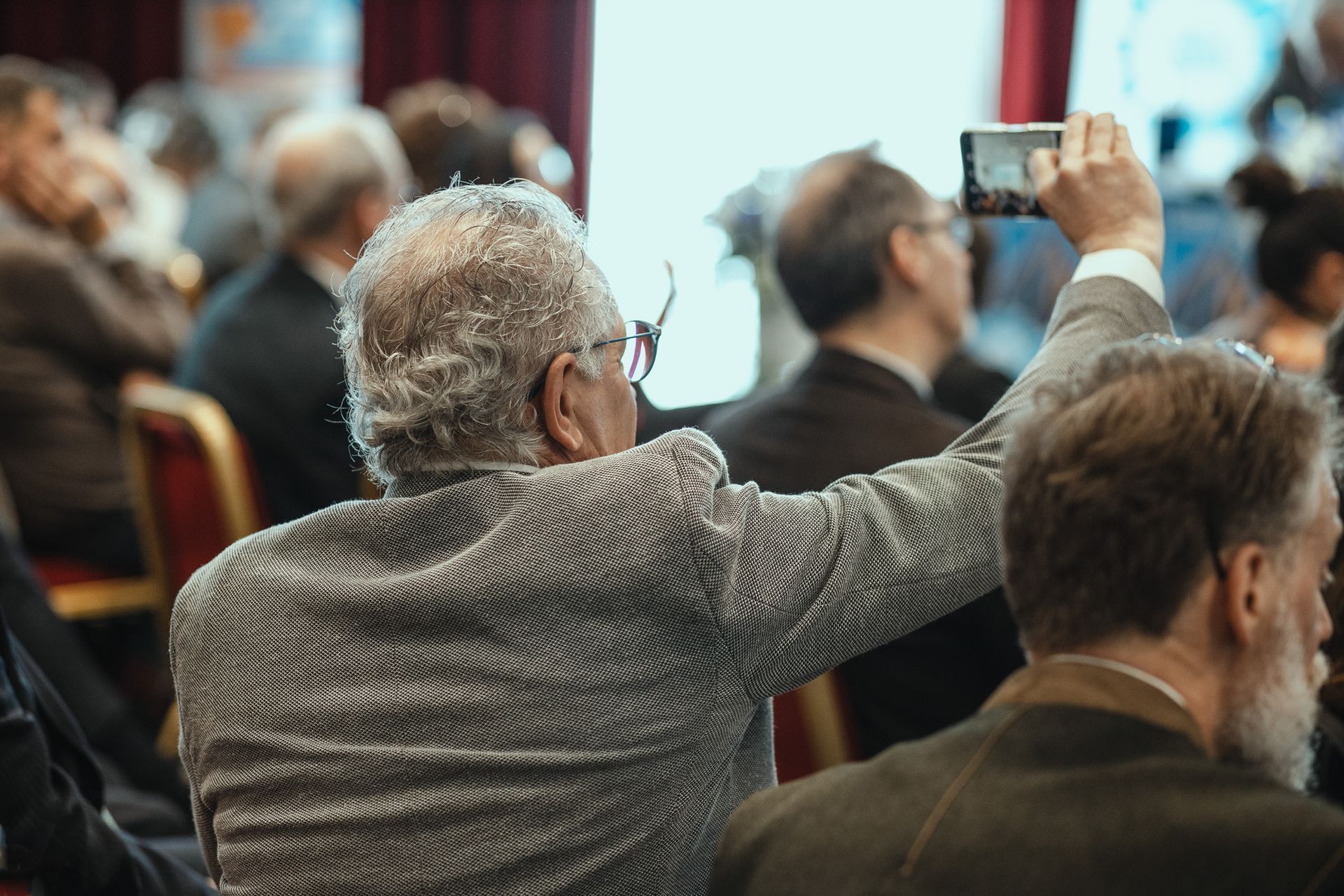 Un uomo sta scattando una foto a un altro uomo con un cellulare.