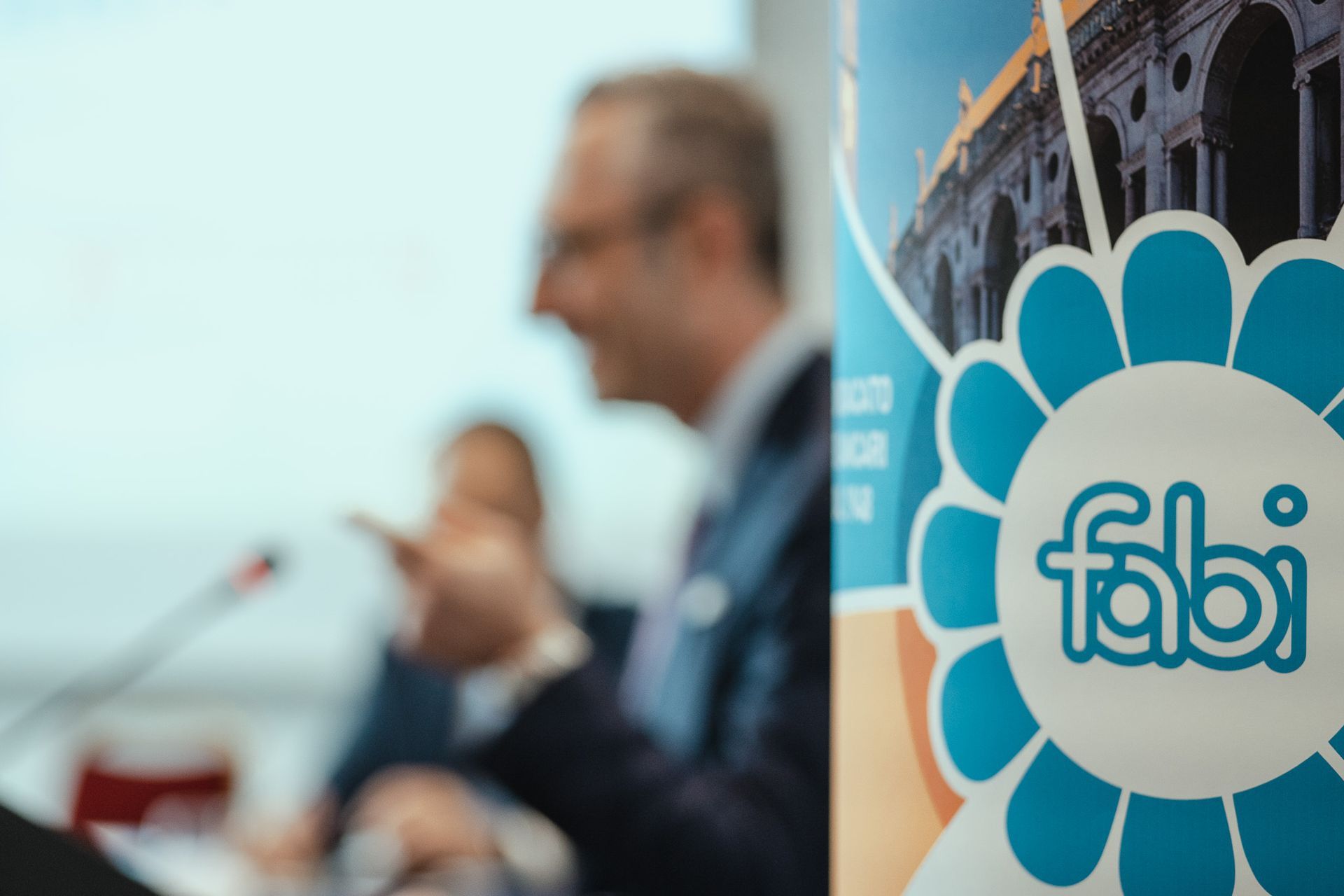 Un uomo tiene un discorso davanti a un logo fabi