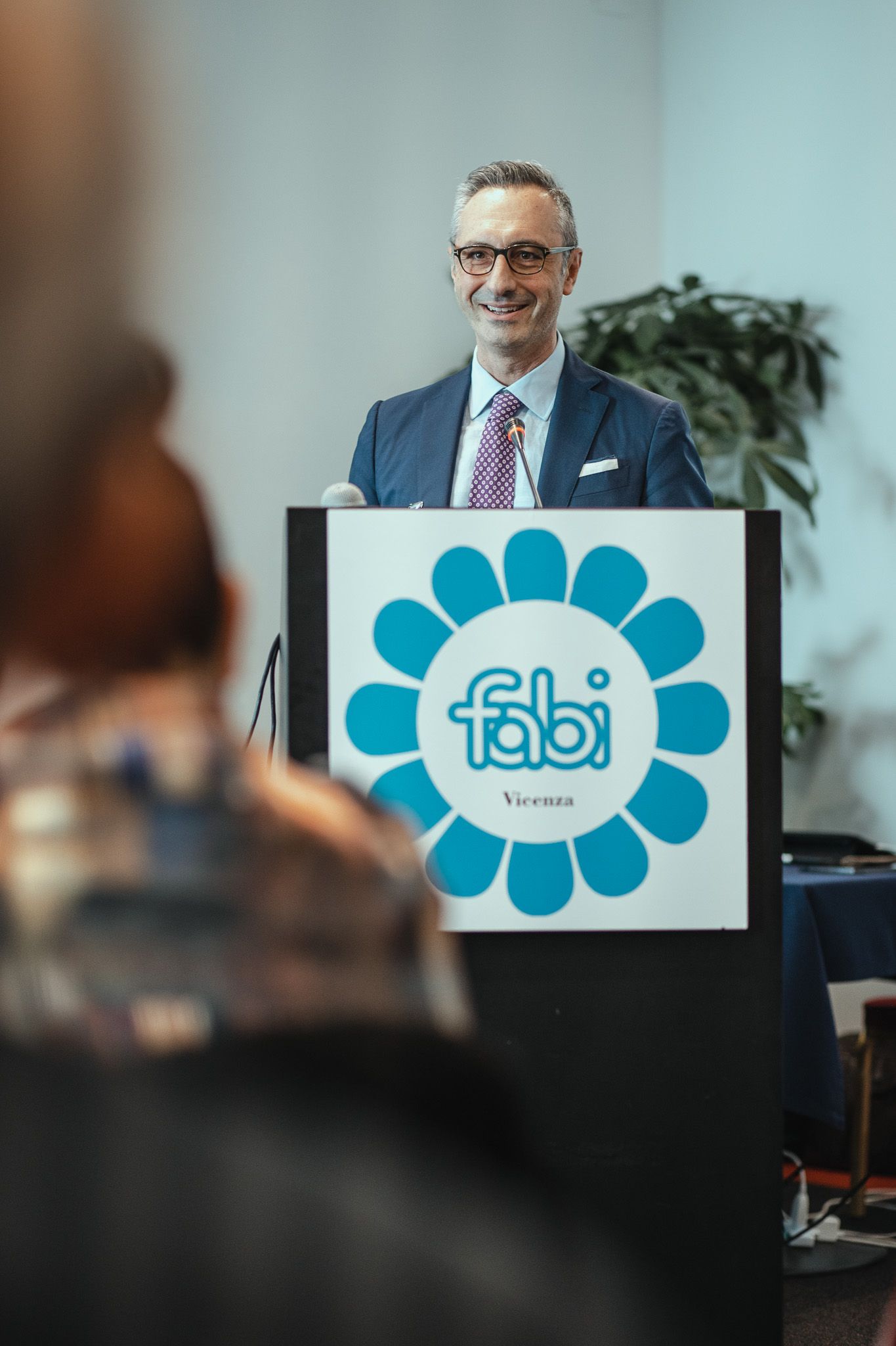 Un uomo è in piedi su un podio con sopra il logo Fabi.