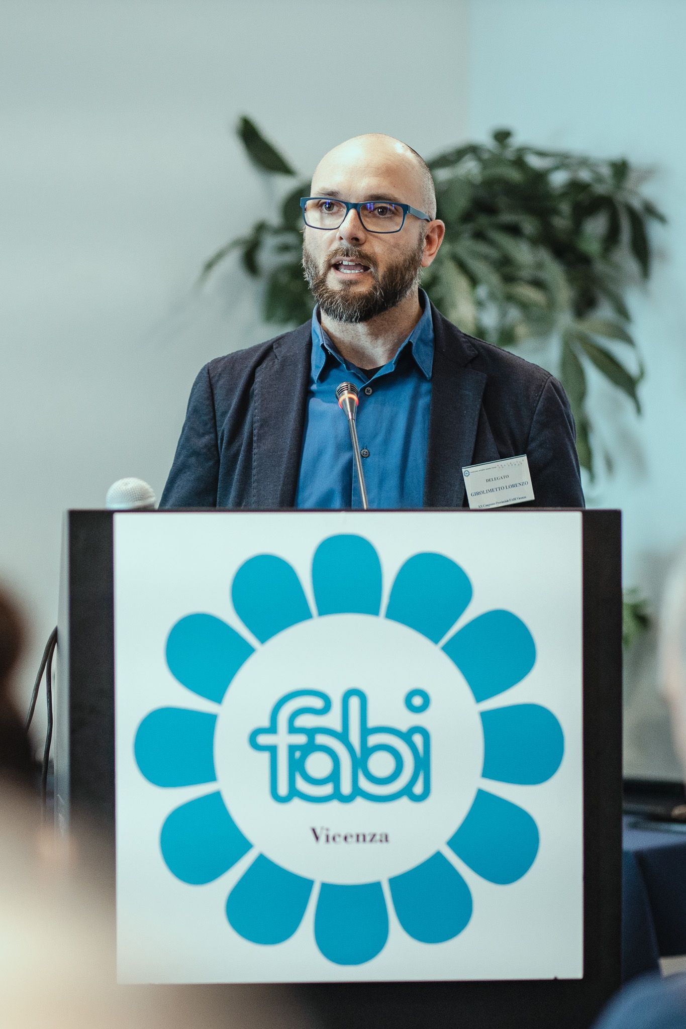 Un uomo sta su un podio con sopra il logo Fabi