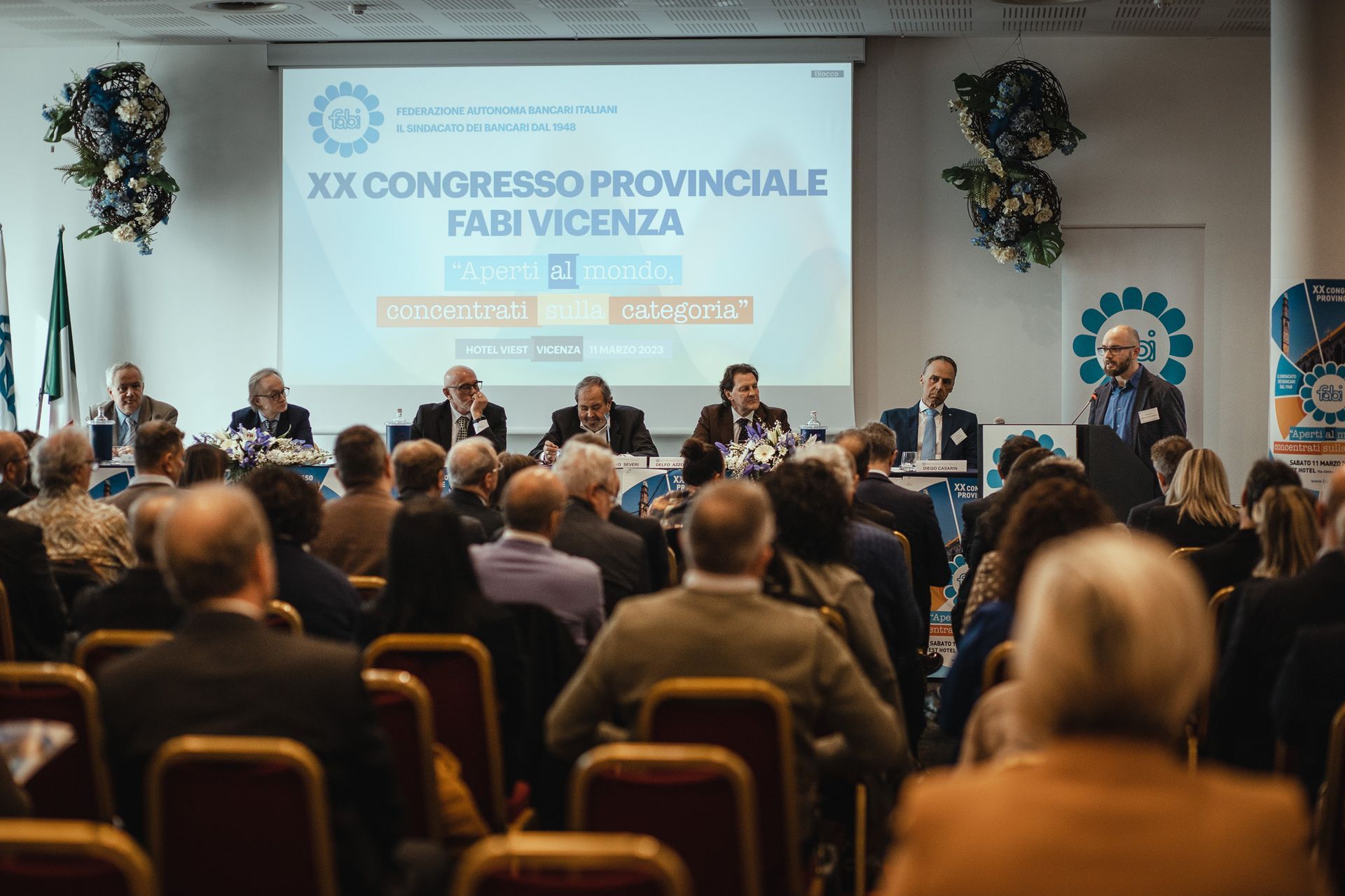 Un gruppo di persone è seduto in una stanza e guarda una presentazione.