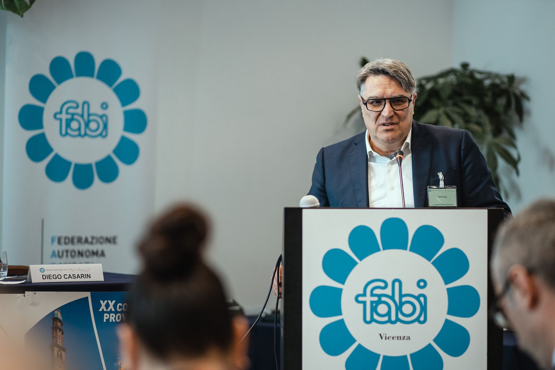 Un uomo è in piedi su un podio e tiene un discorso.