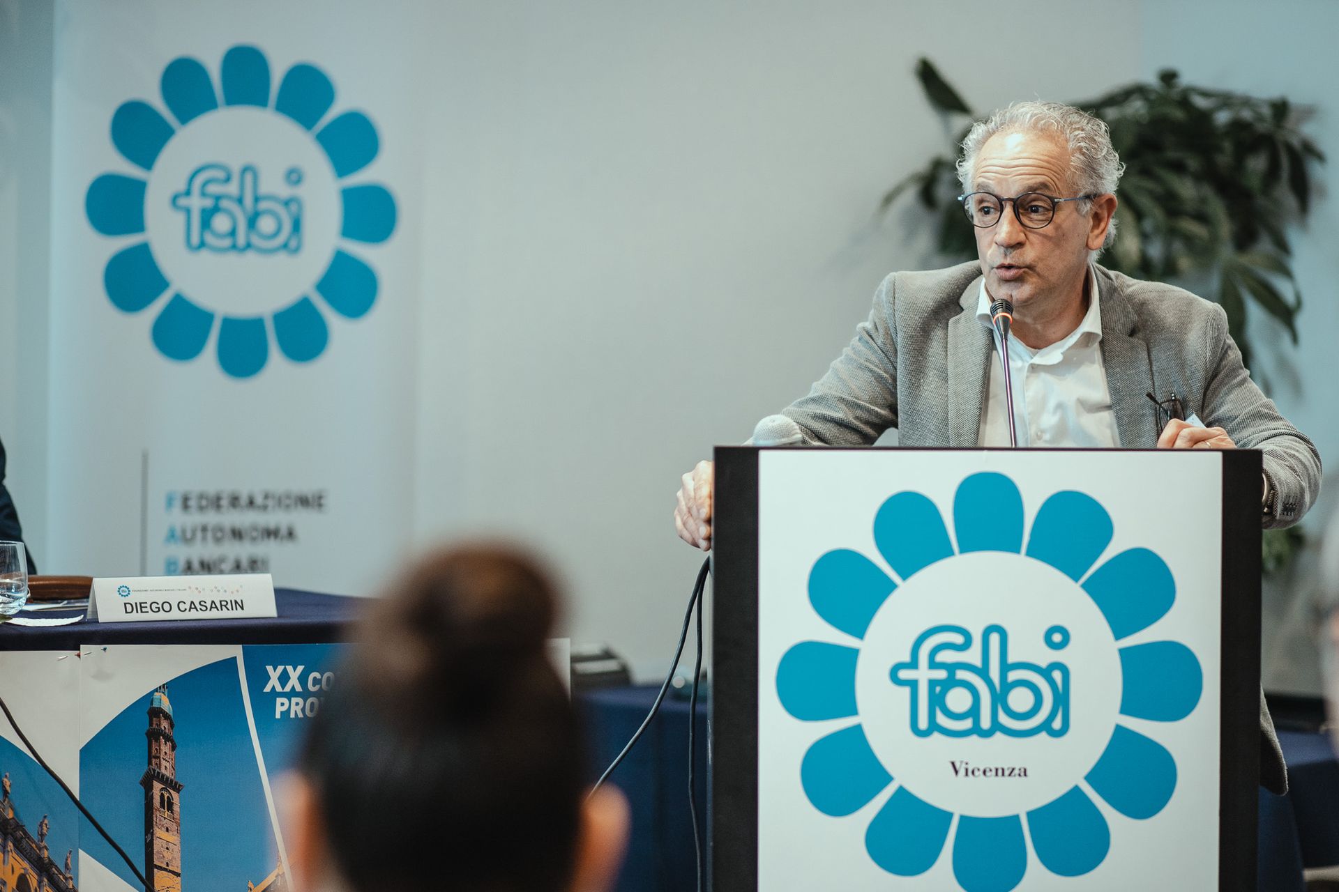 Un uomo sta su un podio con sopra il logo Fabi