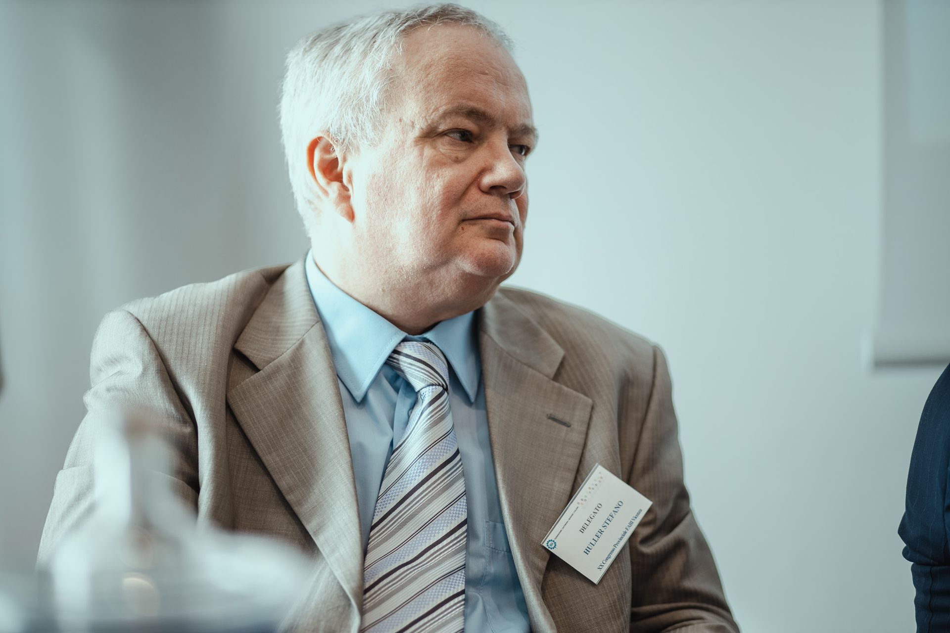 Un uomo in giacca e cravatta è seduto a un tavolo.