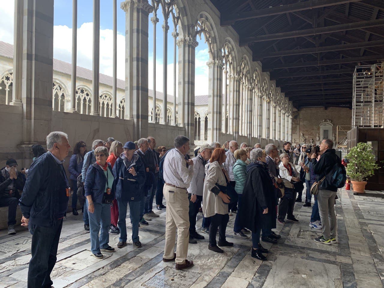 Un gruppo di persone è in piedi in una stanza con colonne.
