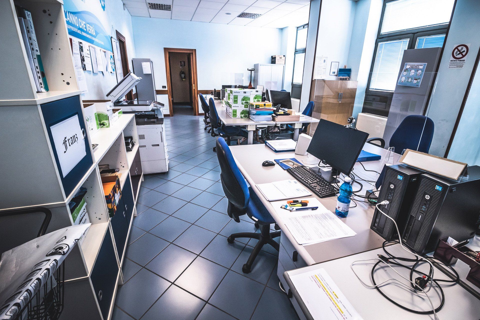 Una stanza con tante scrivanie e computer