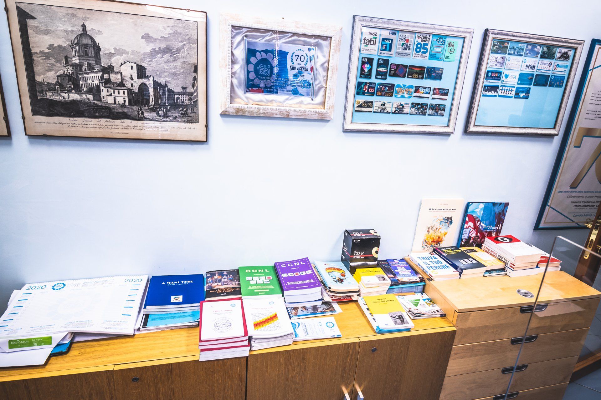 Una cassettiera di legno con sopra un mucchio di libri