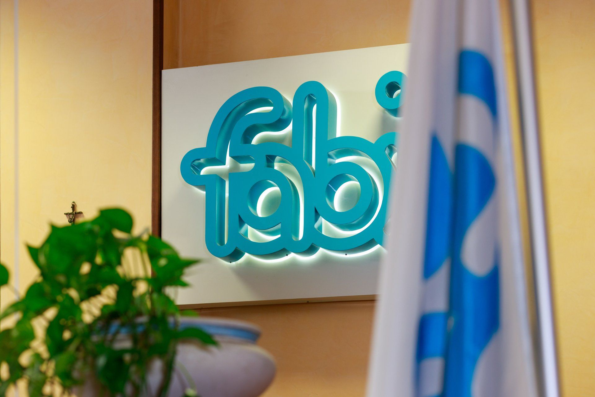 Una bandiera blu e bianca sventola davanti a un cartello che dice fab.