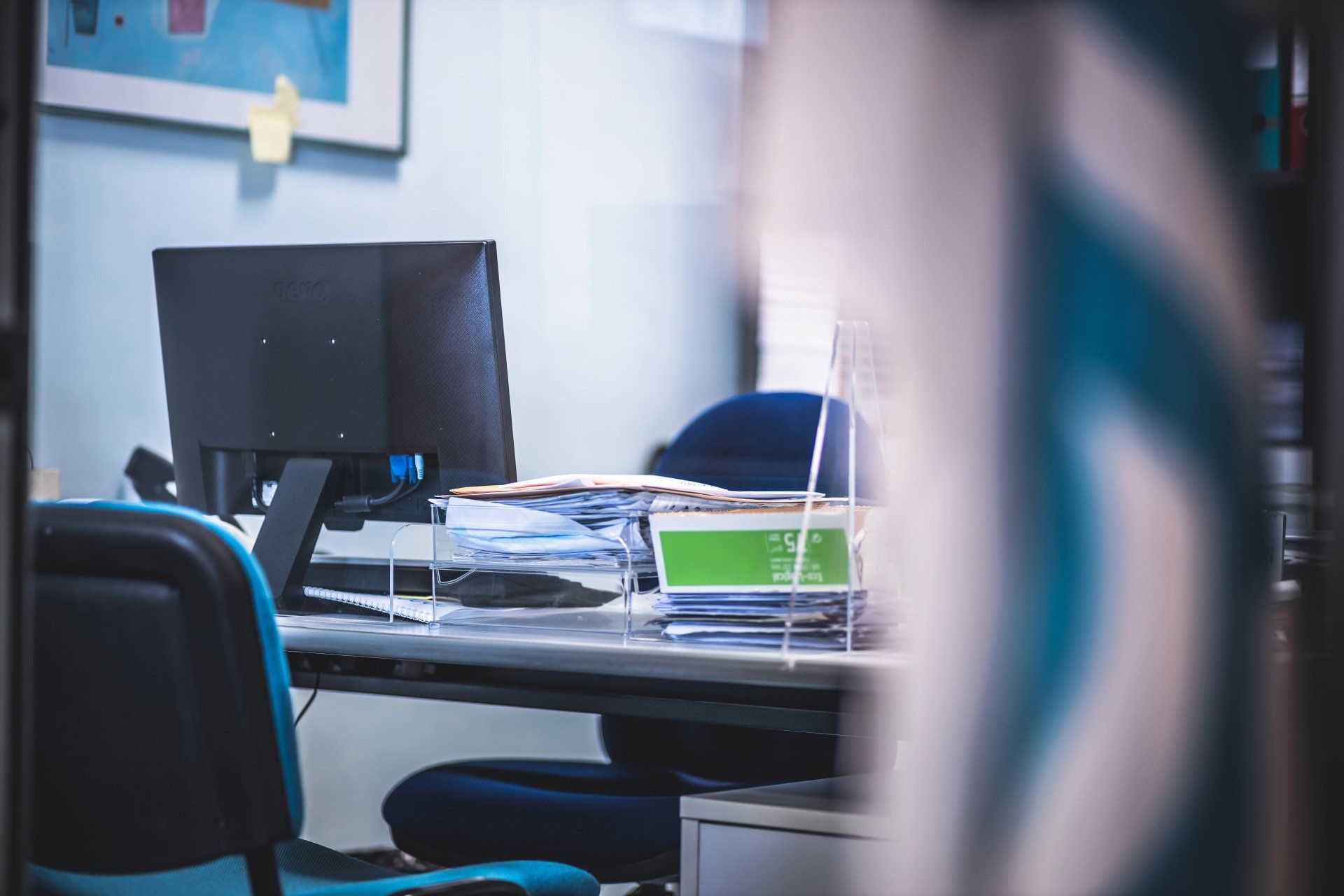 Una scrivania con un computer e una sedia in un ufficio.